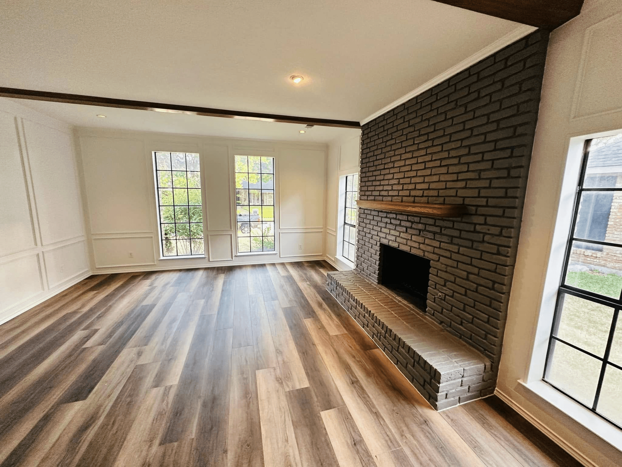 A newly renovated living room with a wooden floor and plenty of light.