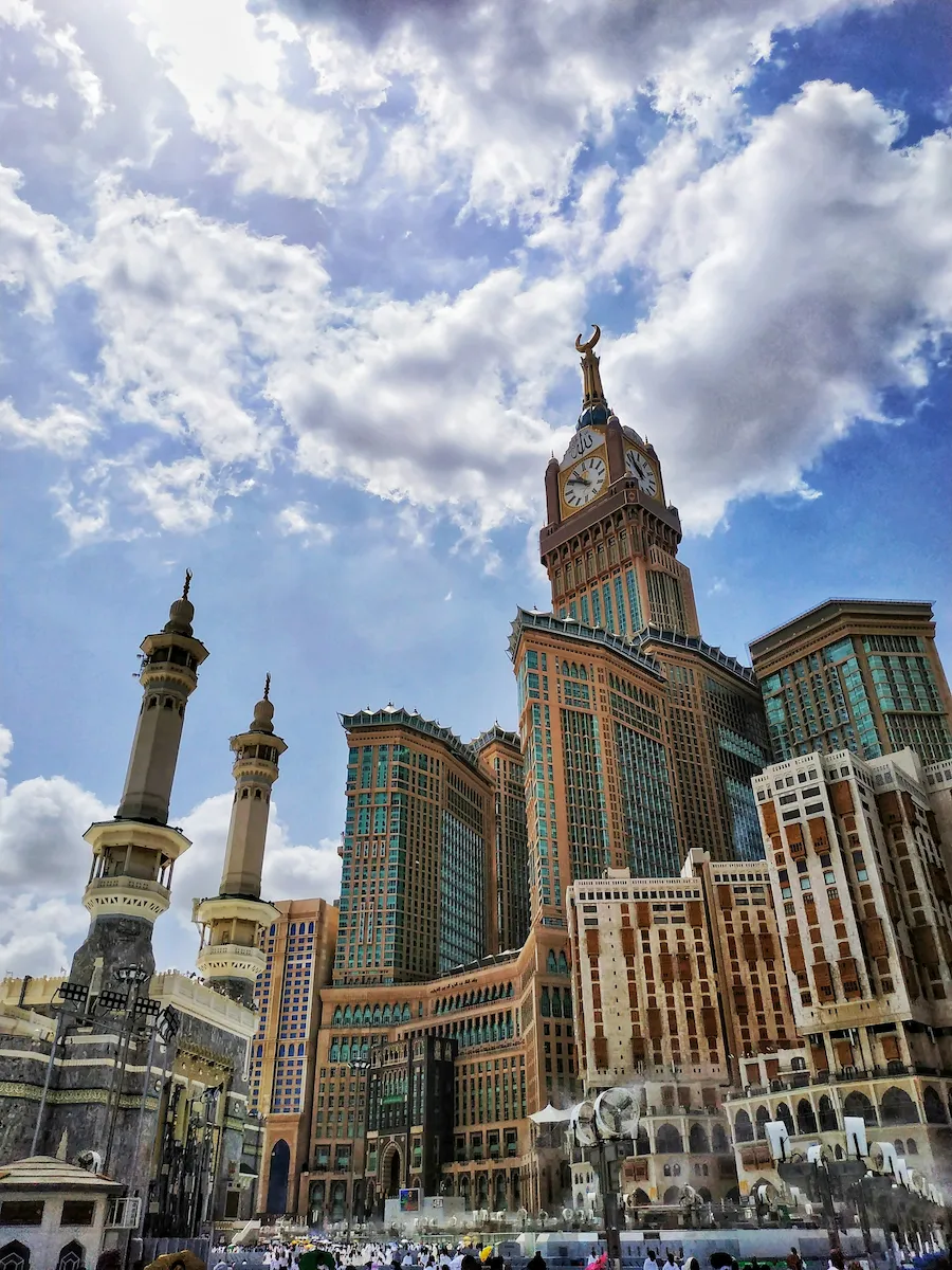 Abraj Al Bait Clock Tower overlooking Masjid al-Haram in Mecca under a bright sky.