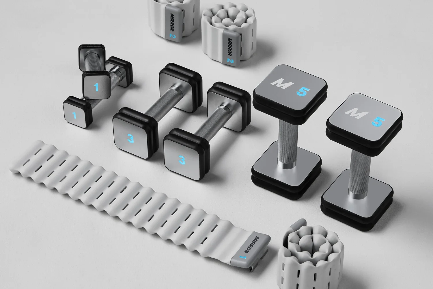 Smart dumbbells and adjustable fitness weights arranged on a light gray background