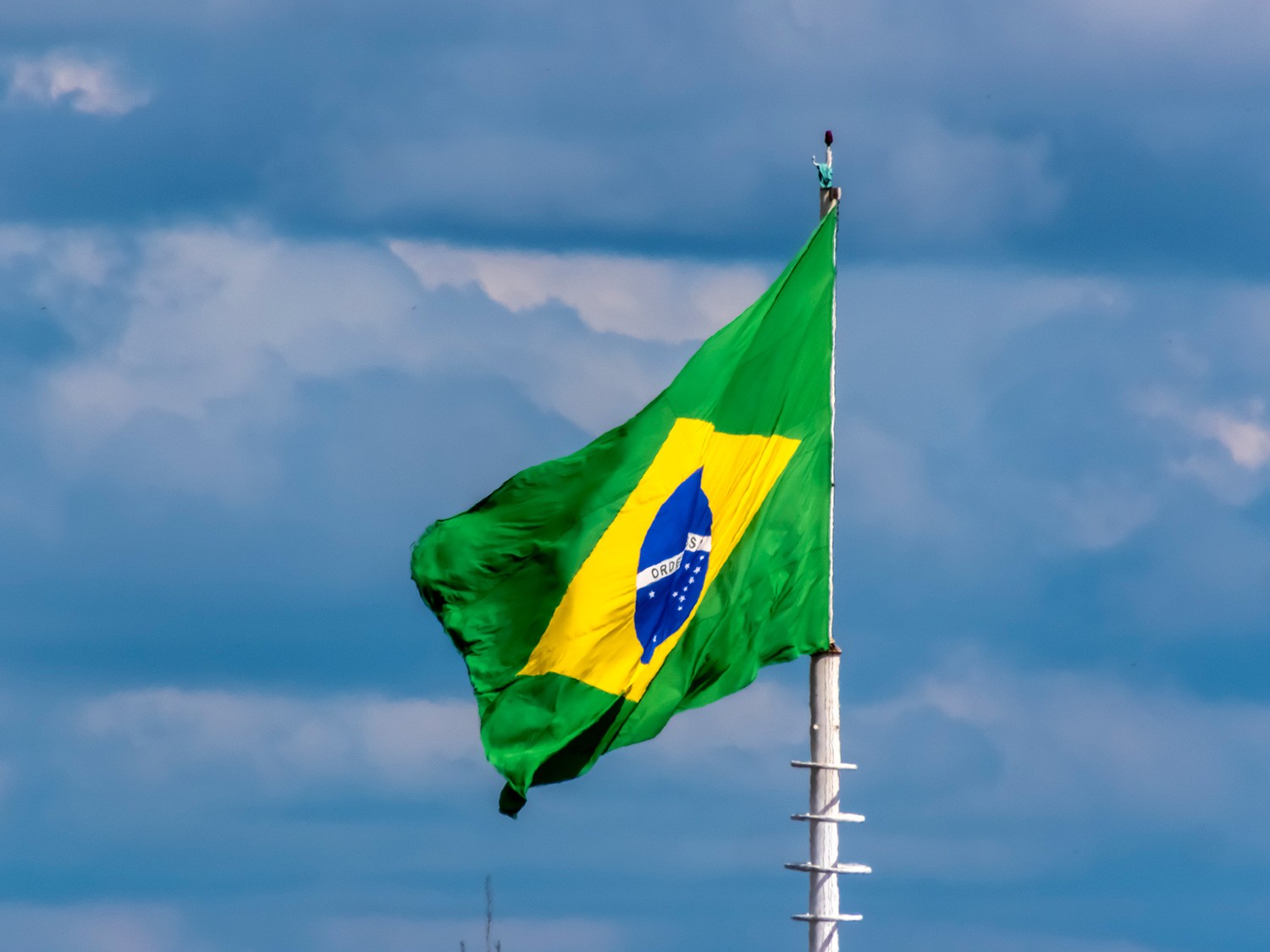 Flag of Brazil, in blue sky