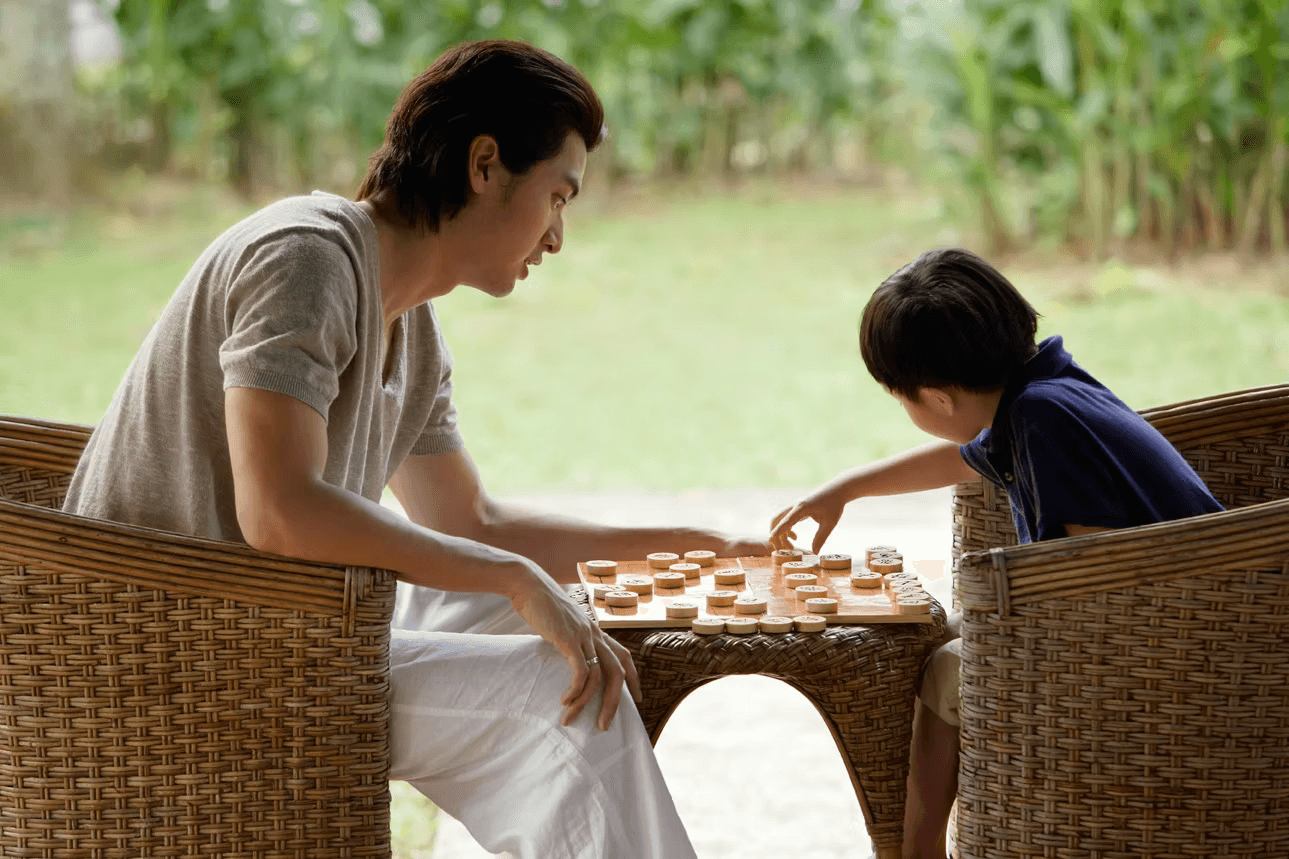 Father playing chess with his son