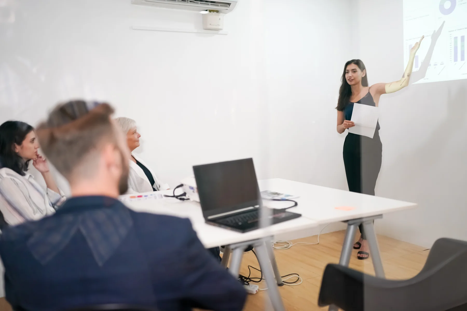 Woman Presents Data to Colleagues in Office
