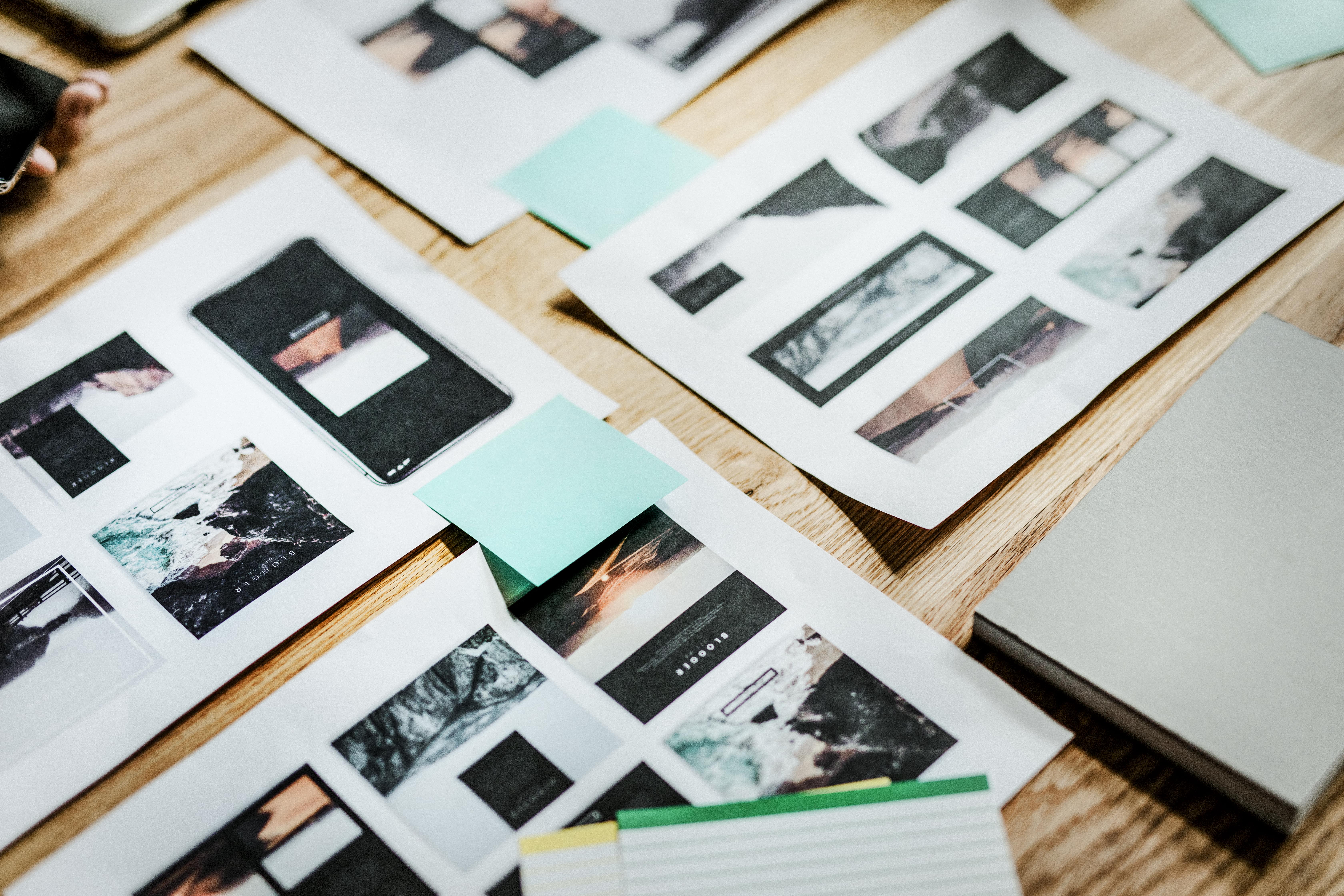 Branding moodboard and layout designs on a wooden table with photo mockups, sticky notes, and social media planning materials