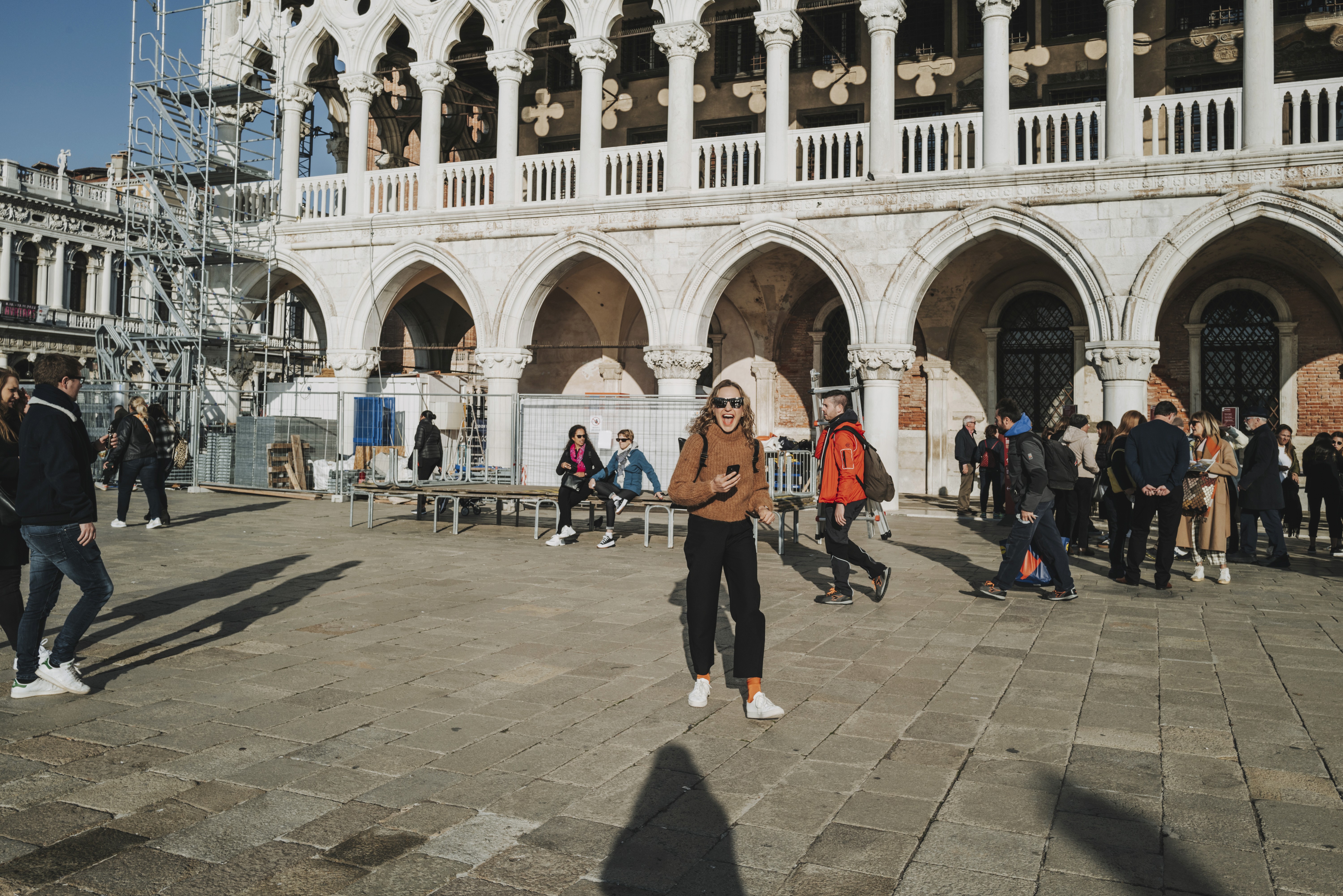 Tree branches reach towards a clear, blue sky.