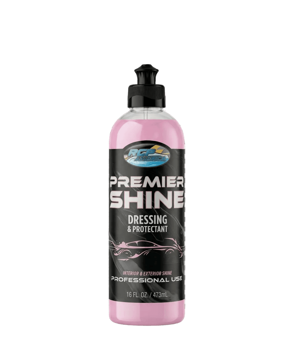 A bottle of Premier Shine Dressing & Protectant car care liquid with a pink liquid inside and a black cap, shown on a black and white checkered transparency background.