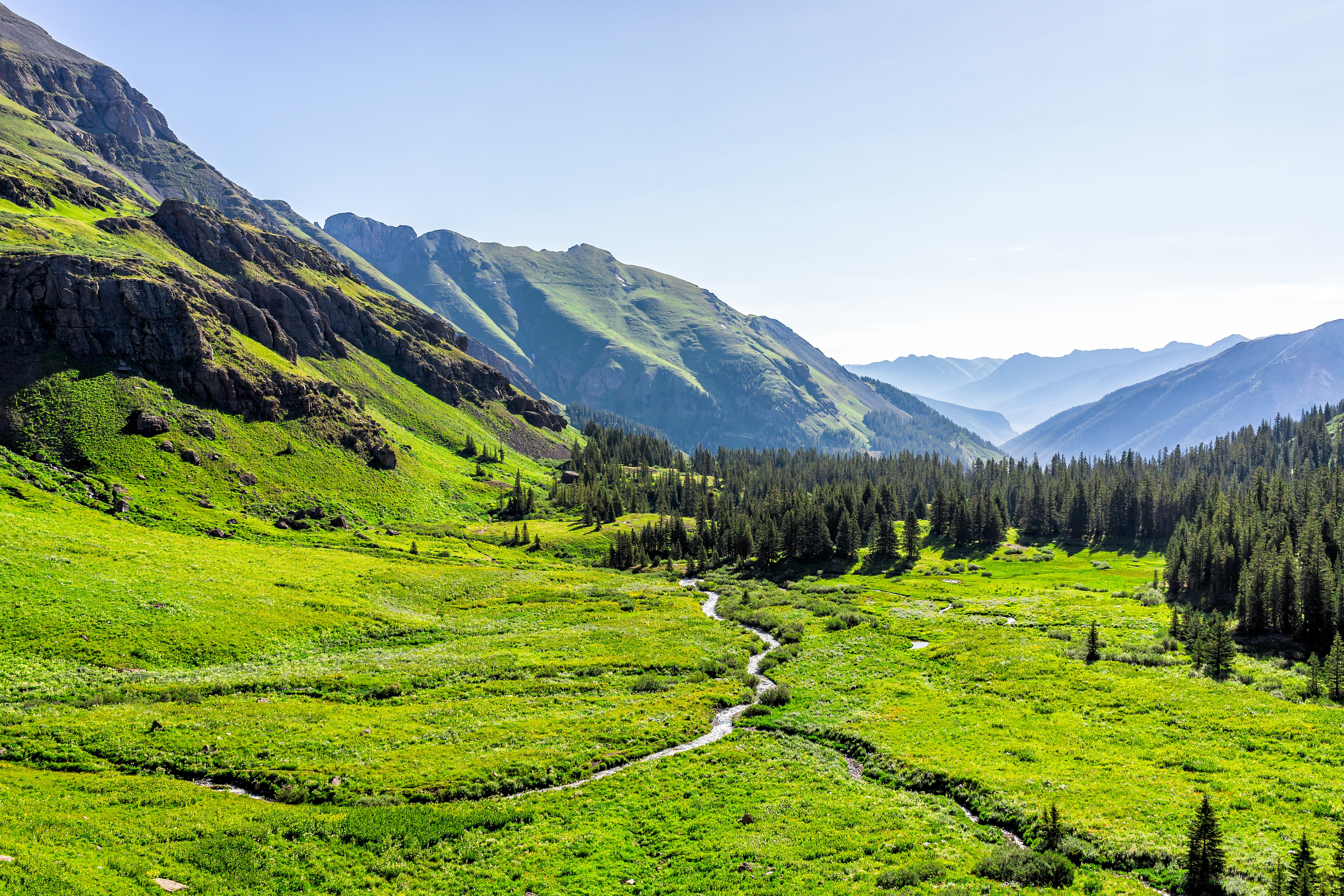 woman in blue tank top standing beside white wall