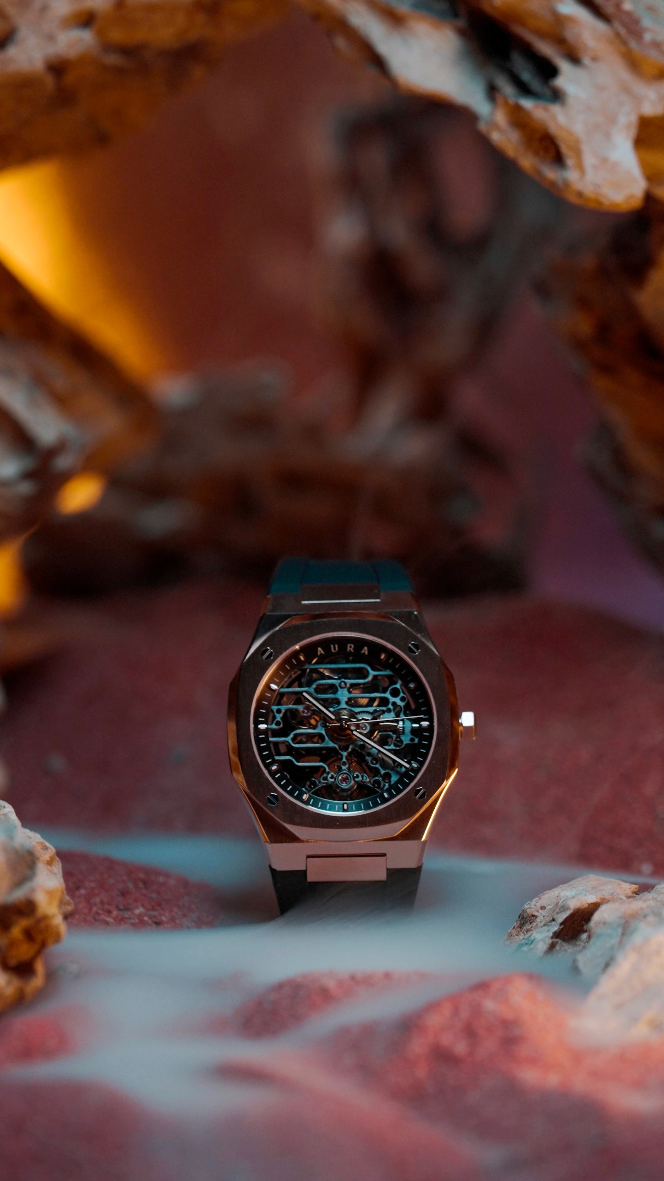 Minimalist Aura watch with black leather strap photographed on textured stone background