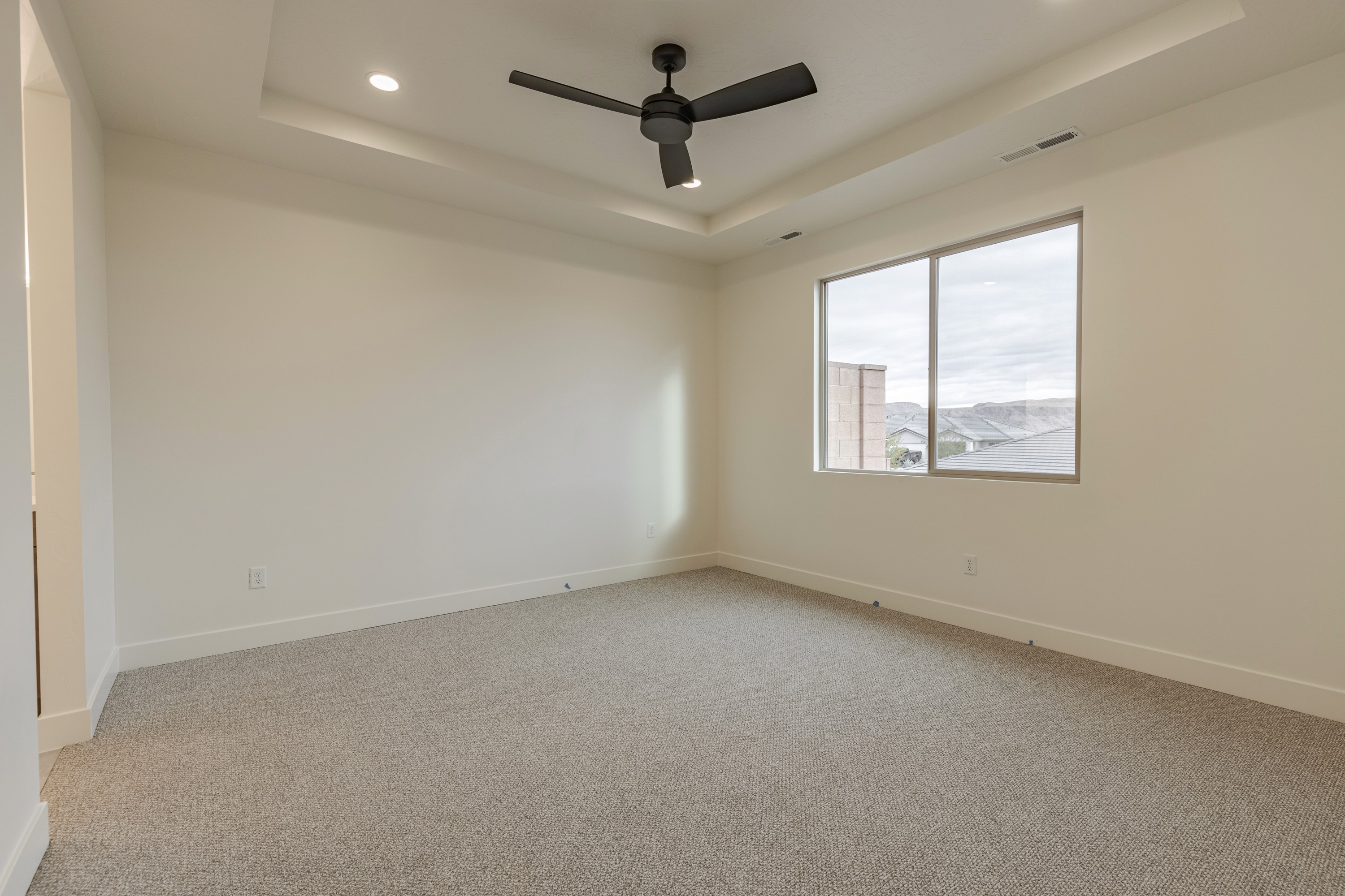Master bedroom in the Painted Sands twin home in Hurricane, Utah featuring a spacious layout and bright windows.