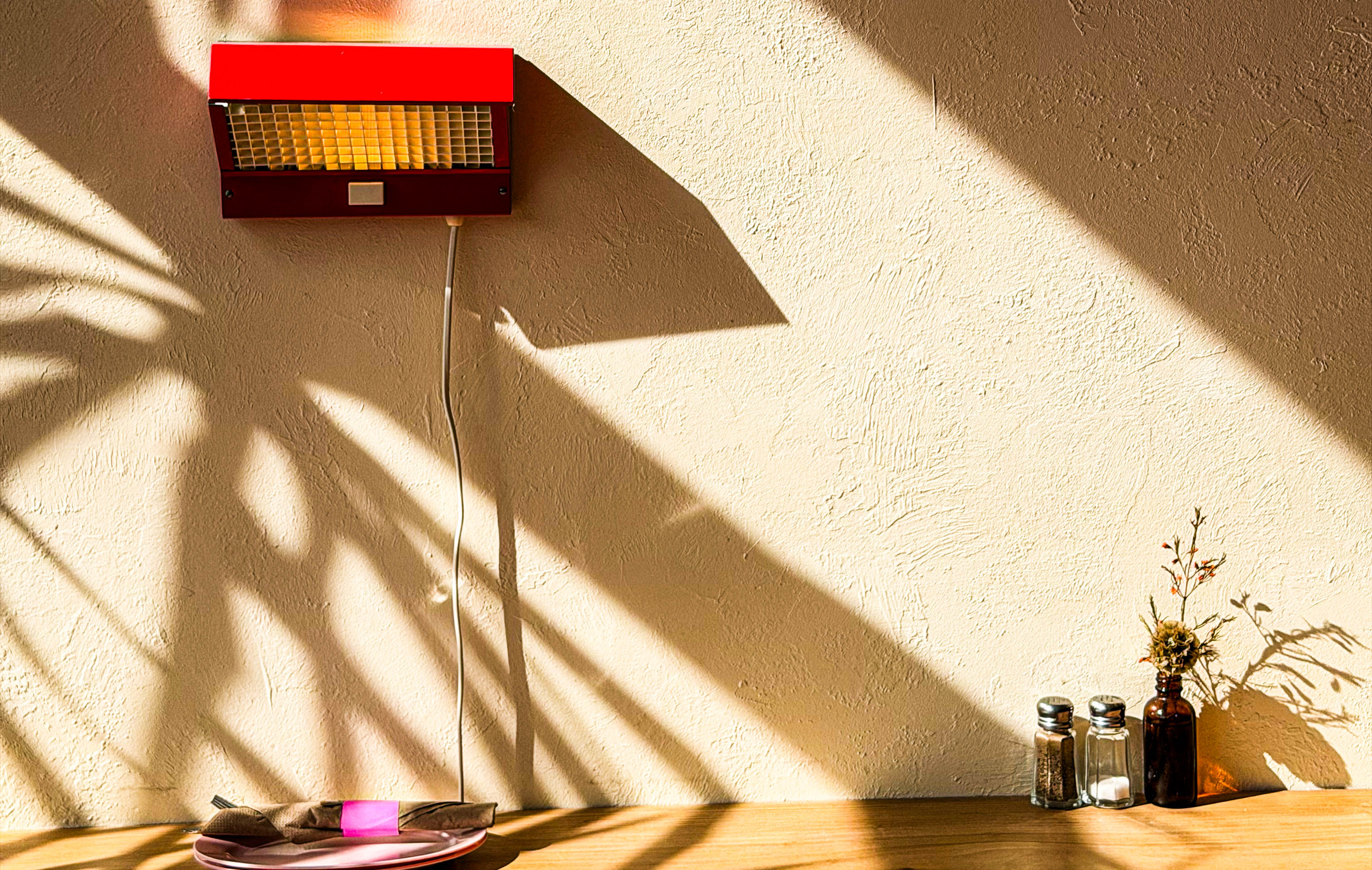 shadows on a wall creating interesting lines above a wooden bar