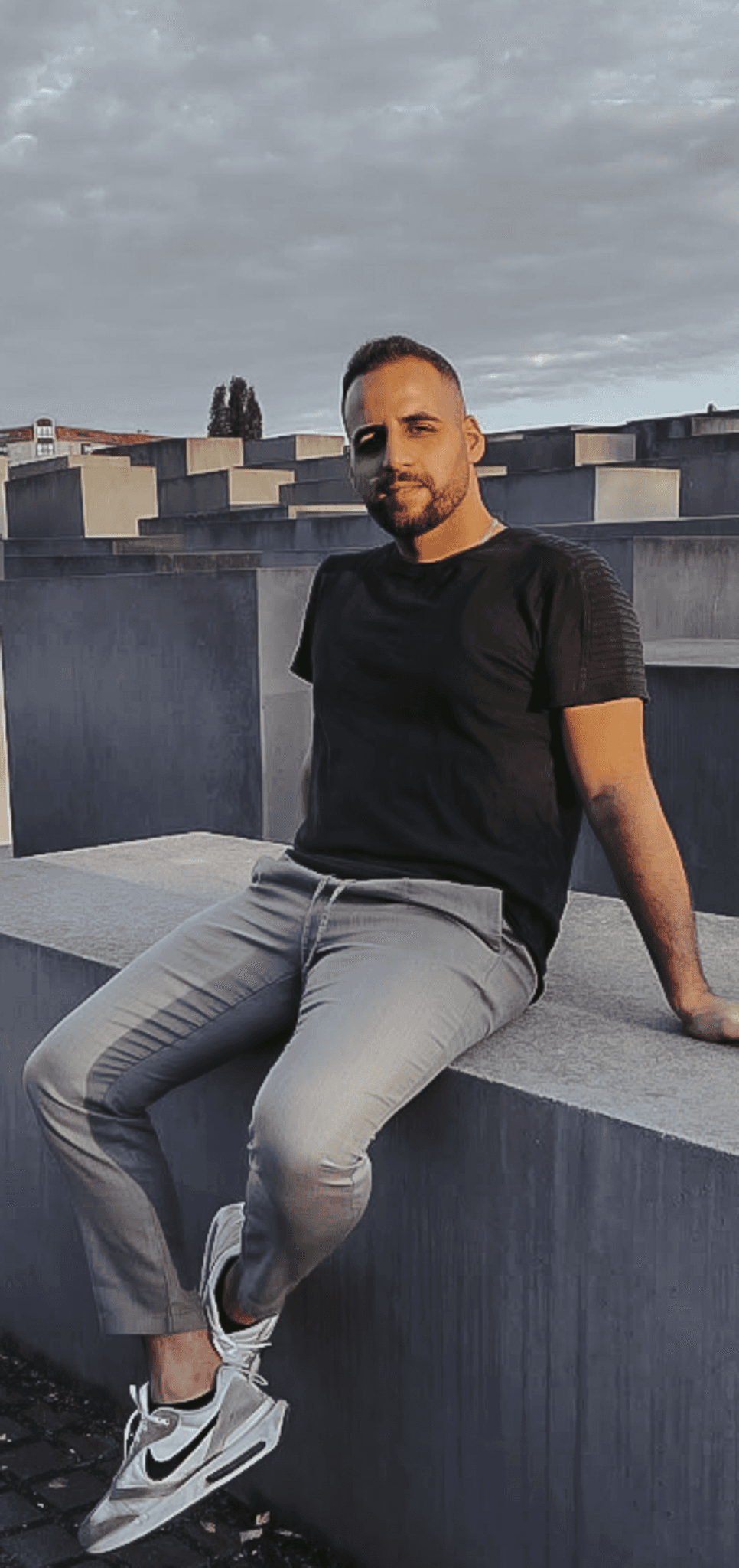 Profile portrait of a man in a white shirt against a light background