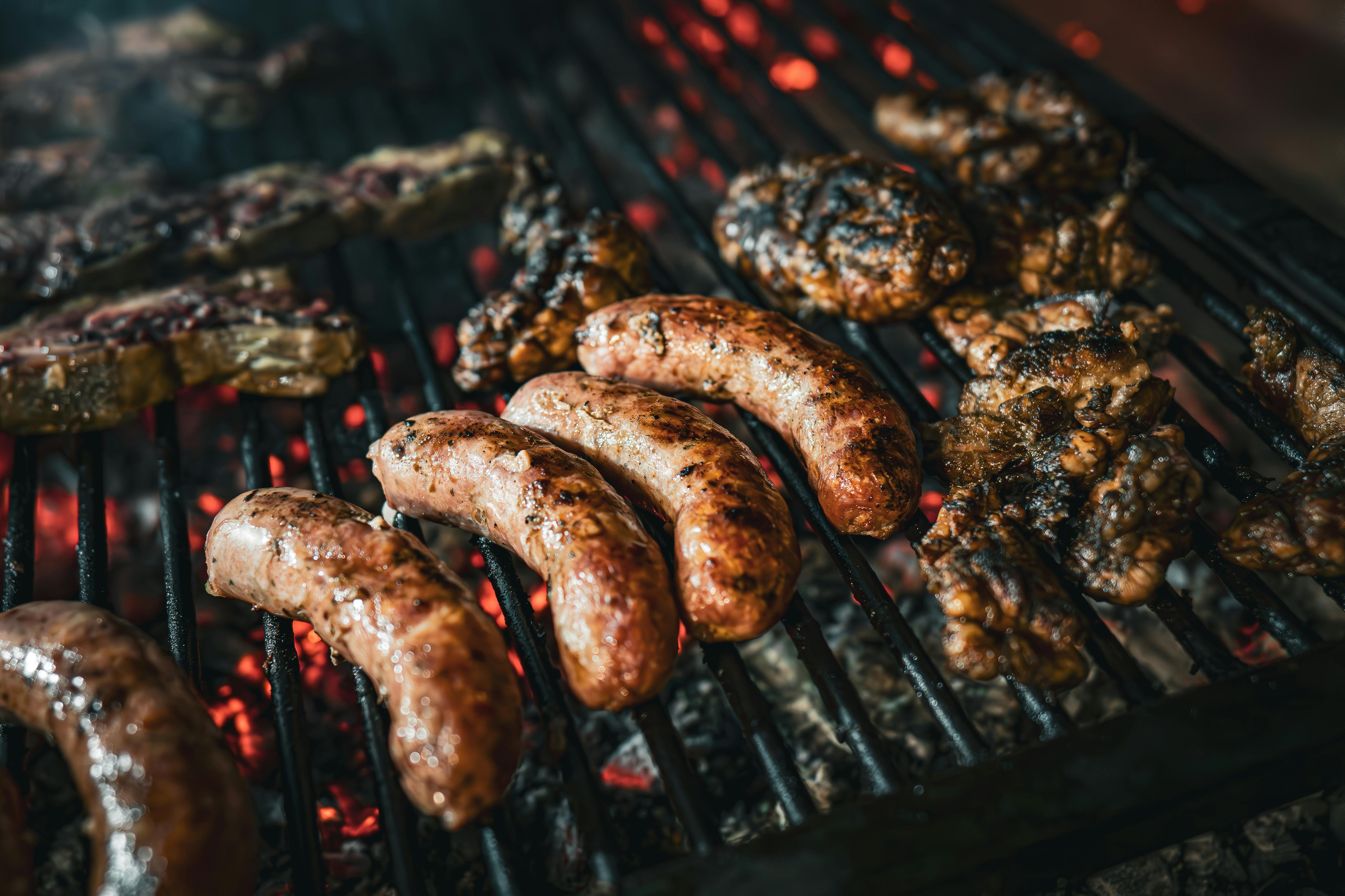 Parrilla con chorizos y carnes asadas, experiencia gastronómica típica de Uruguay sugerida por una app de turismo para viajeros.