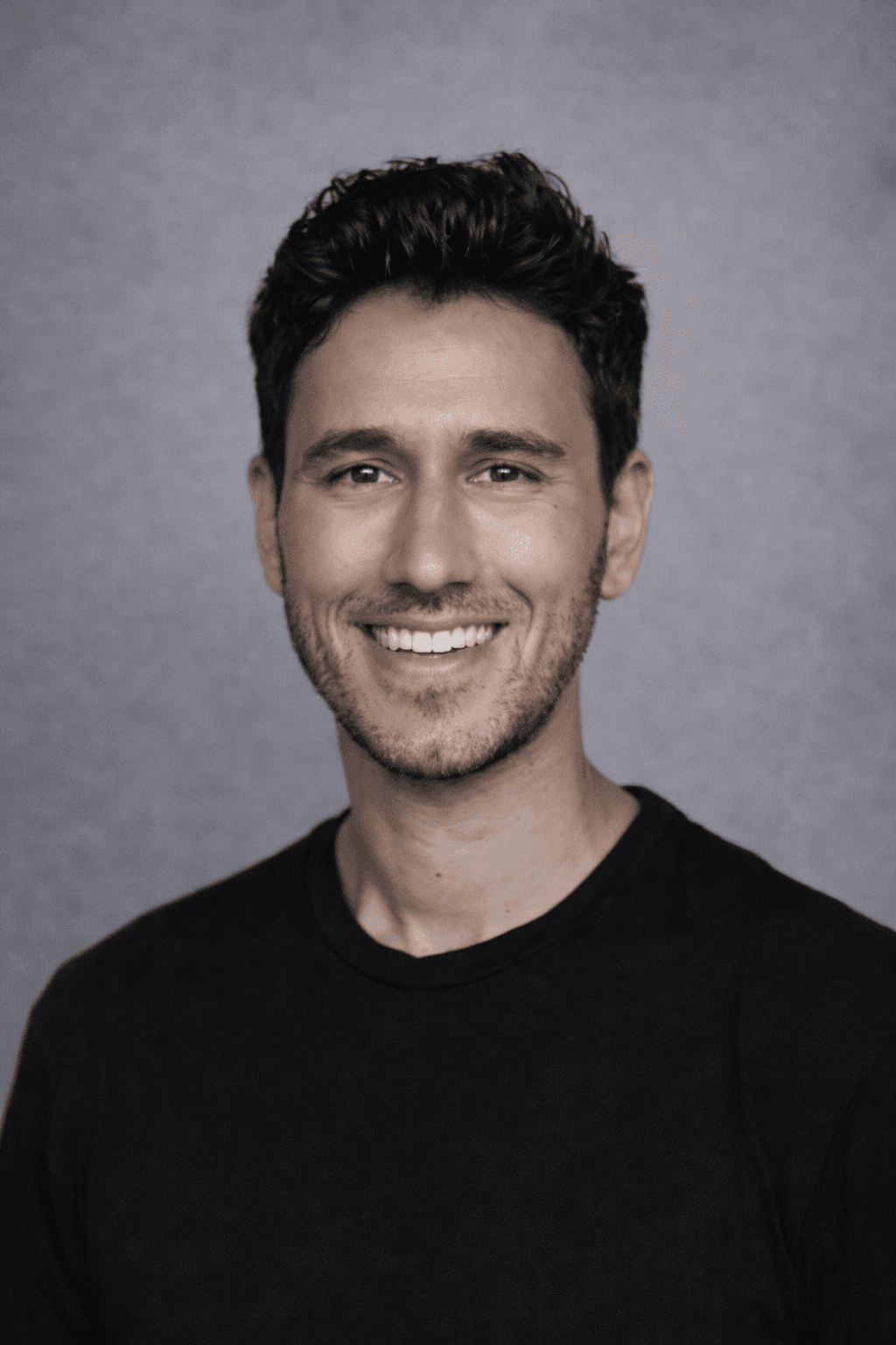 Black and white portrait of a smiling person with curly hair