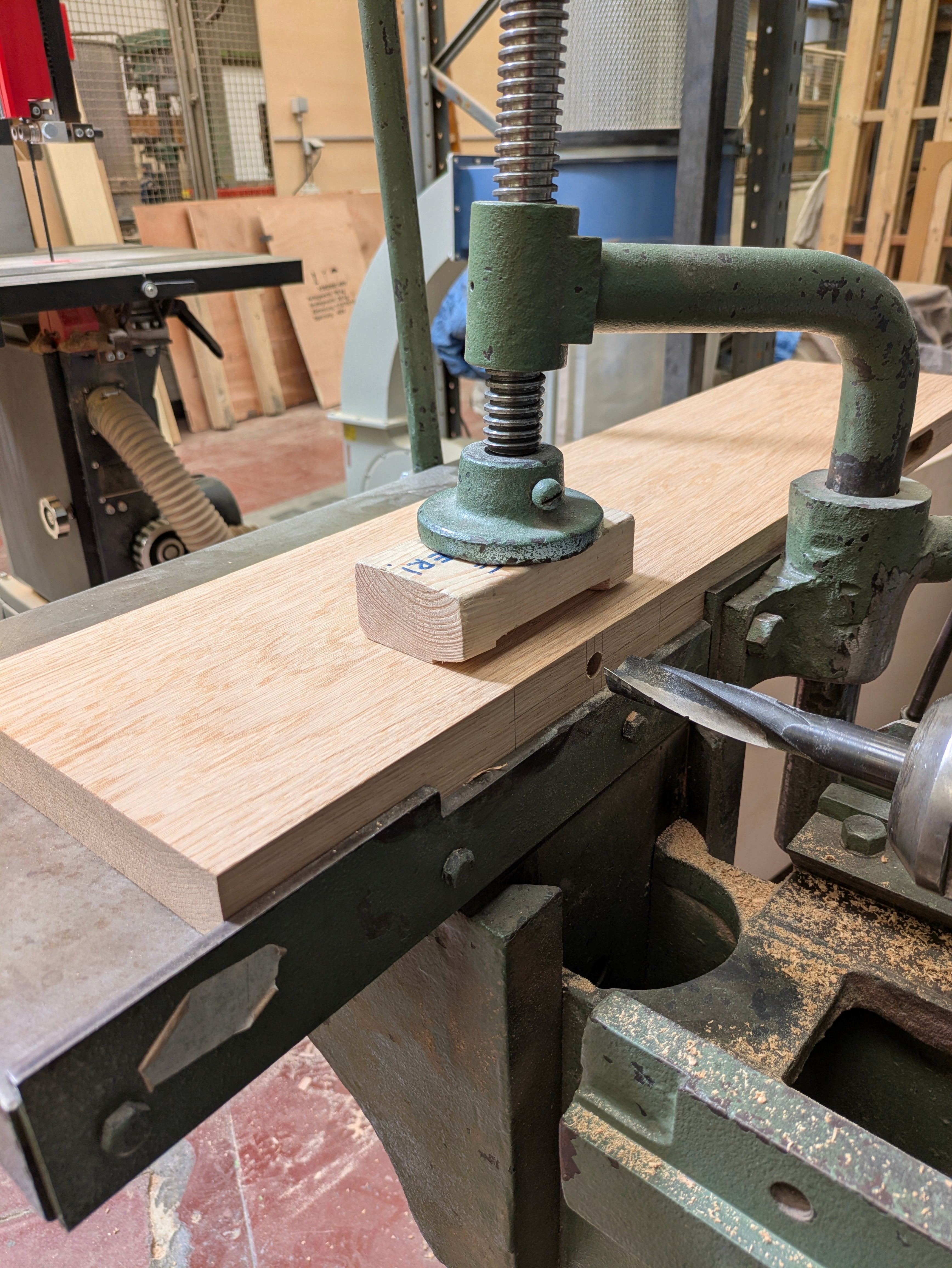 Een wandplank uit gerecupereerd eikenhout op een langgatboormachine