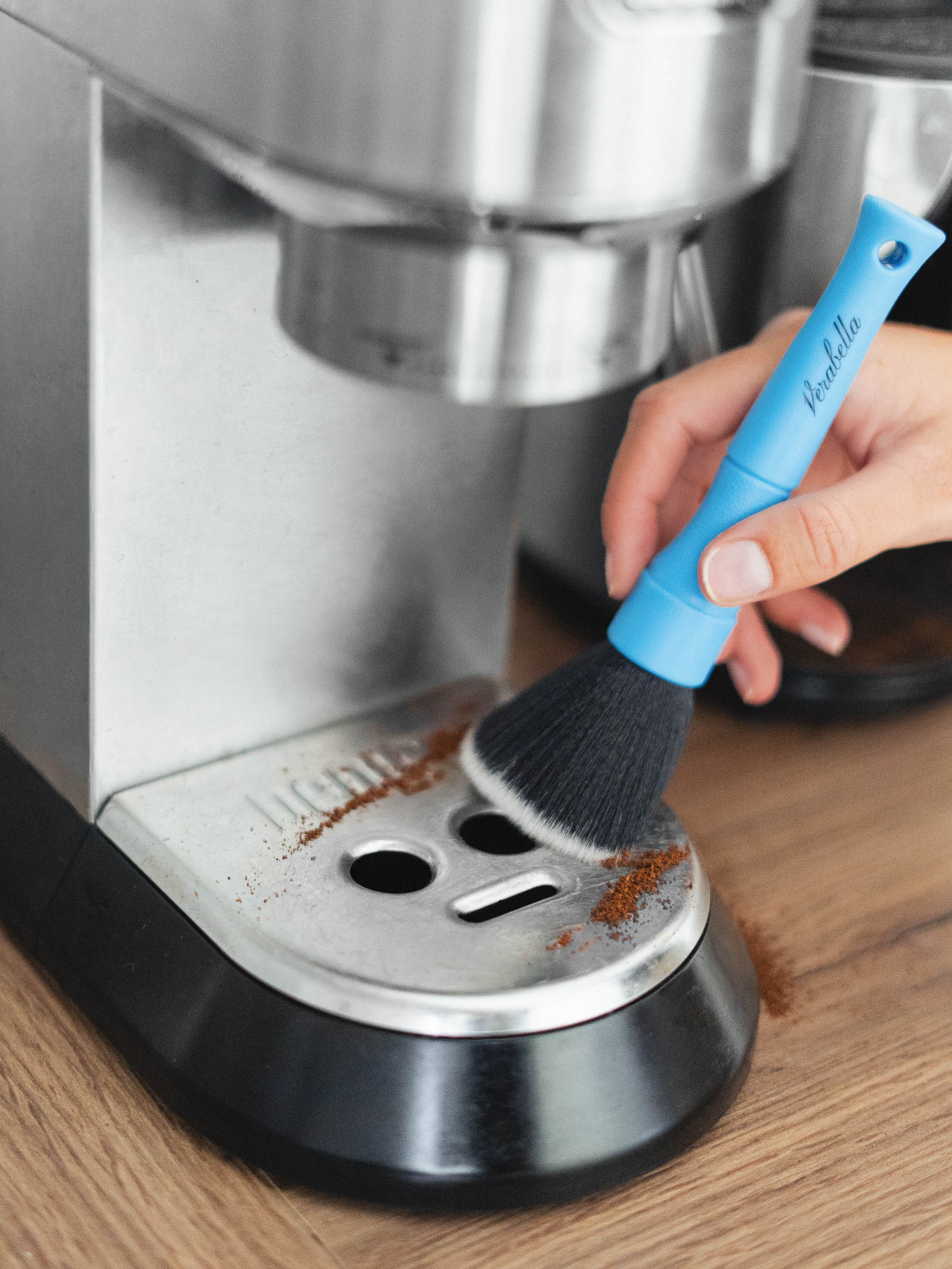 Detailreiche Werbefotografie einer Kaffeemaschinen-Reinigung mit Pinsel von Leon Moik.