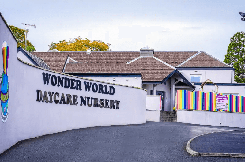 Wonder World Daycare Nursery exterior with rainbow fence and colorful sign.