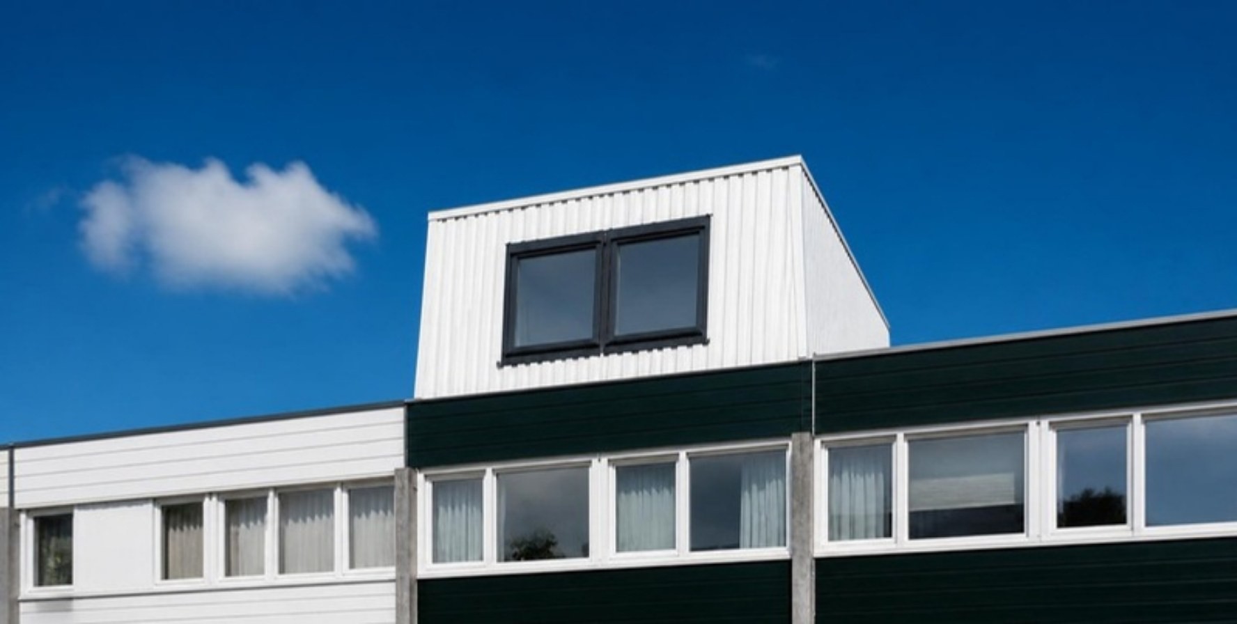 Witte dakopbouw tegen blauwe lucht