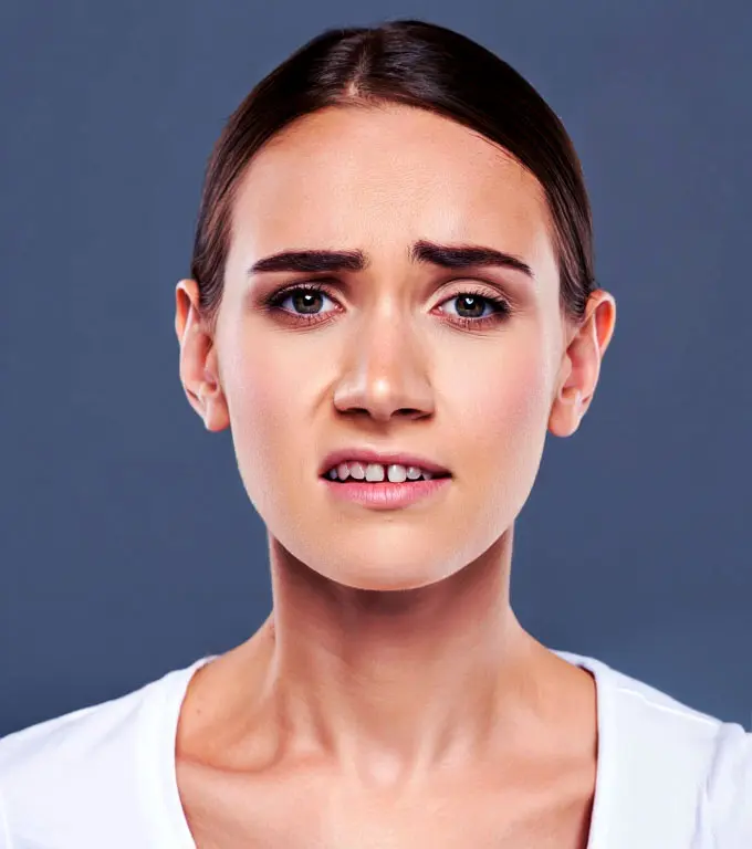 Woman making a disgusted face, with furrowed brows and lips pulled back