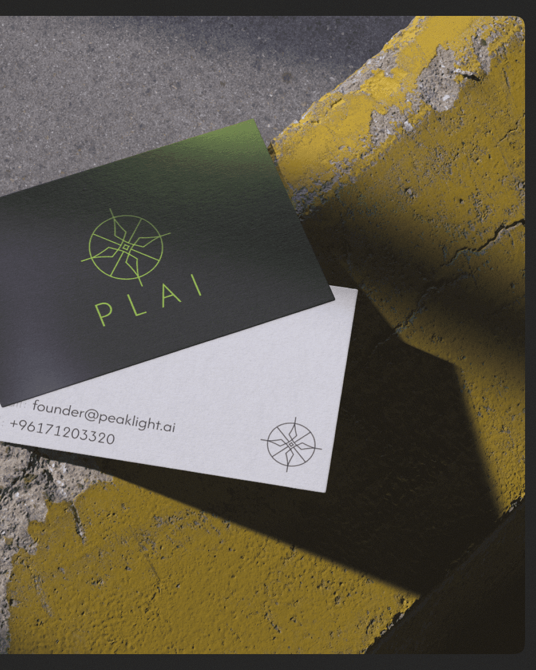 Modern architectural workspace with large floor-to-ceiling windows, surrounded by trees, and desks filled with design materials and books. Two blurred figures are walking through the space.