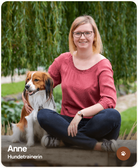 woman smiling holding short-coat brown dog