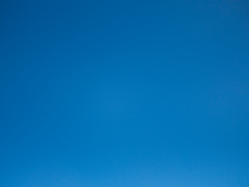 red train travelling near body of water