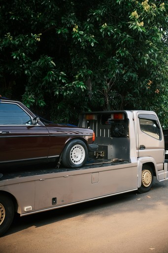 A car being towed on a flatbed truck illustration car import