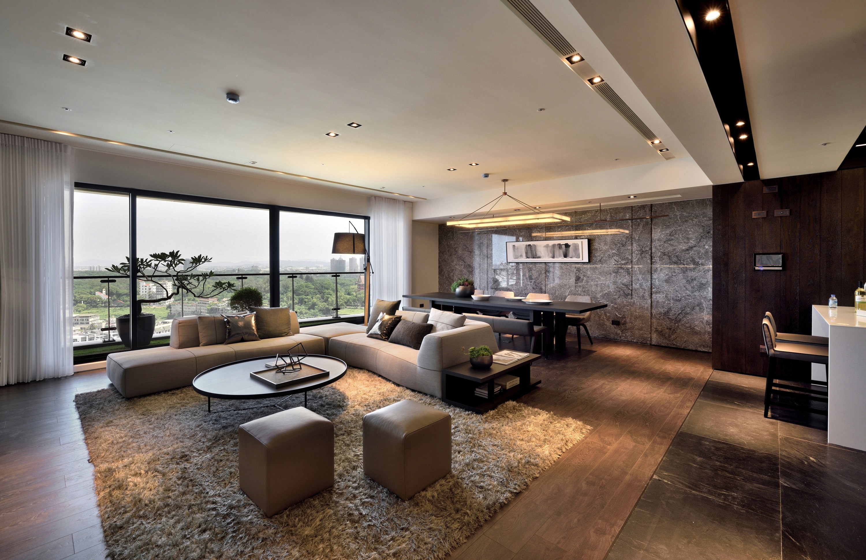 Spacious interior with large windows, stone cladding, and wood flooring.