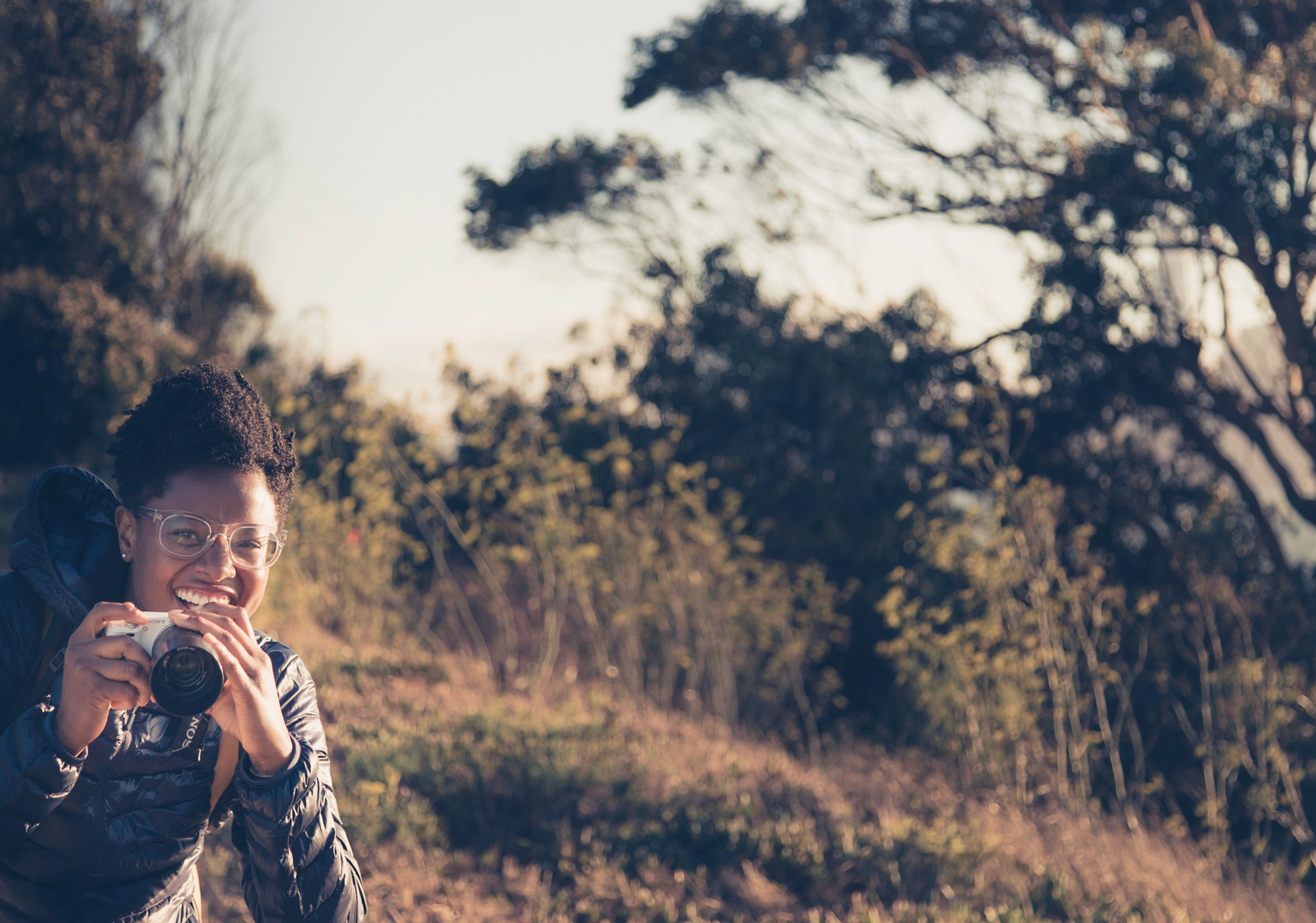 Woman holding camera, smiling