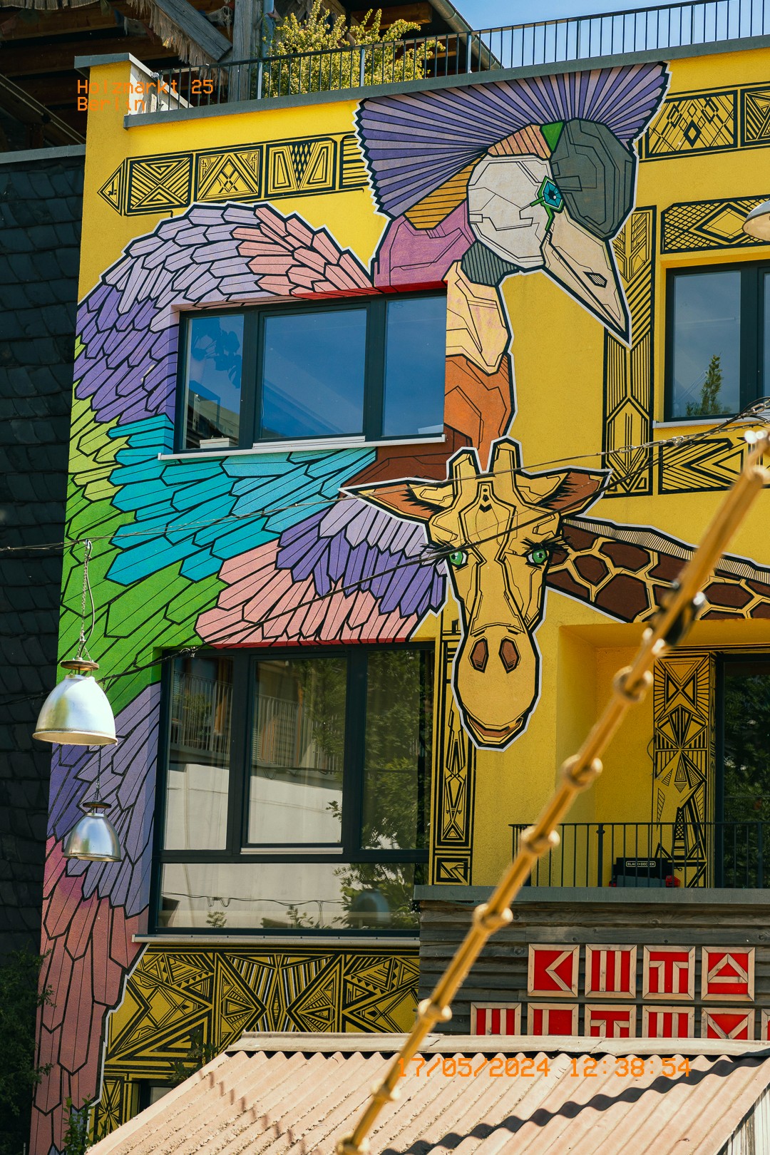 Façade peinte d'une girafe stylisée et motifs colorés.  