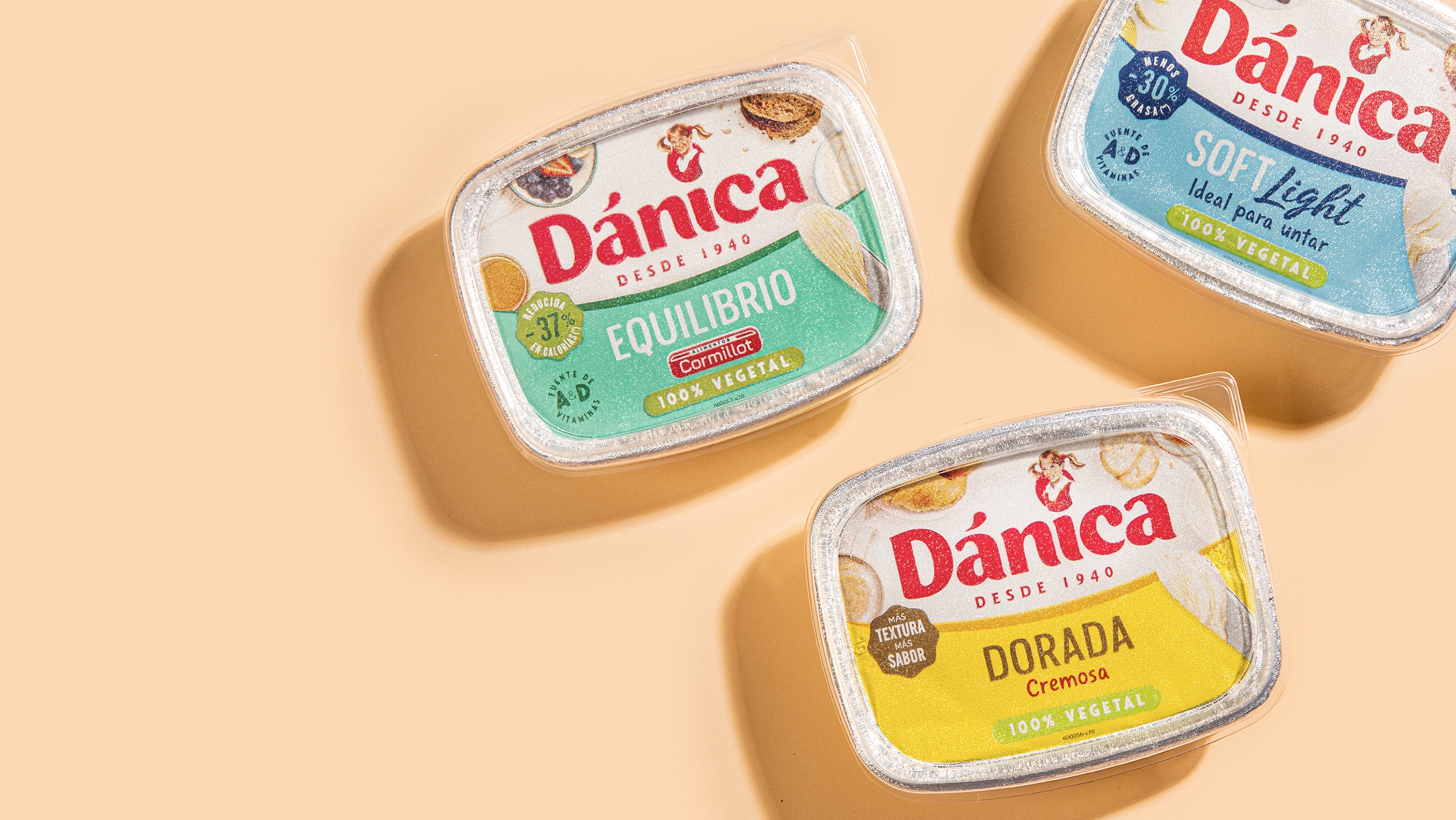 Three Dánica spreads on a beige background. The green-labeled Equilibrio, blue-labeled Soft Light, and yellow-labeled Dorada are vegan products.