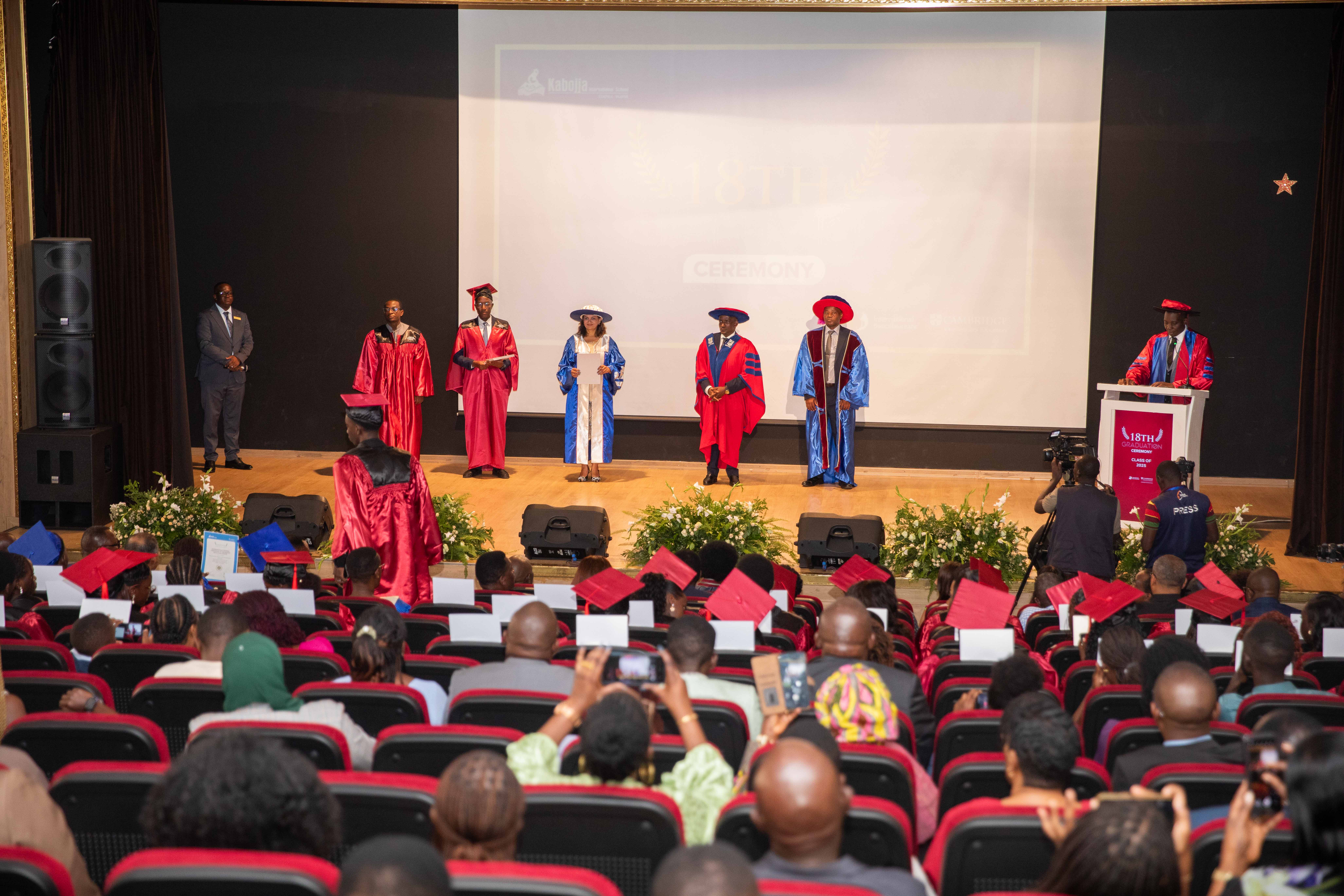 Two cheerful students are balancing books on their heads, smiling and laughing