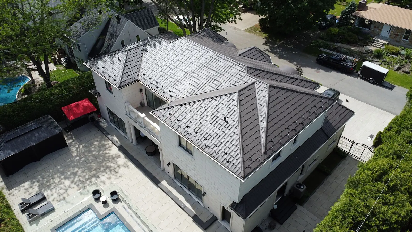 Toiture en tuiles métalliques rouges sur maison résidentielle en briques à Montréal