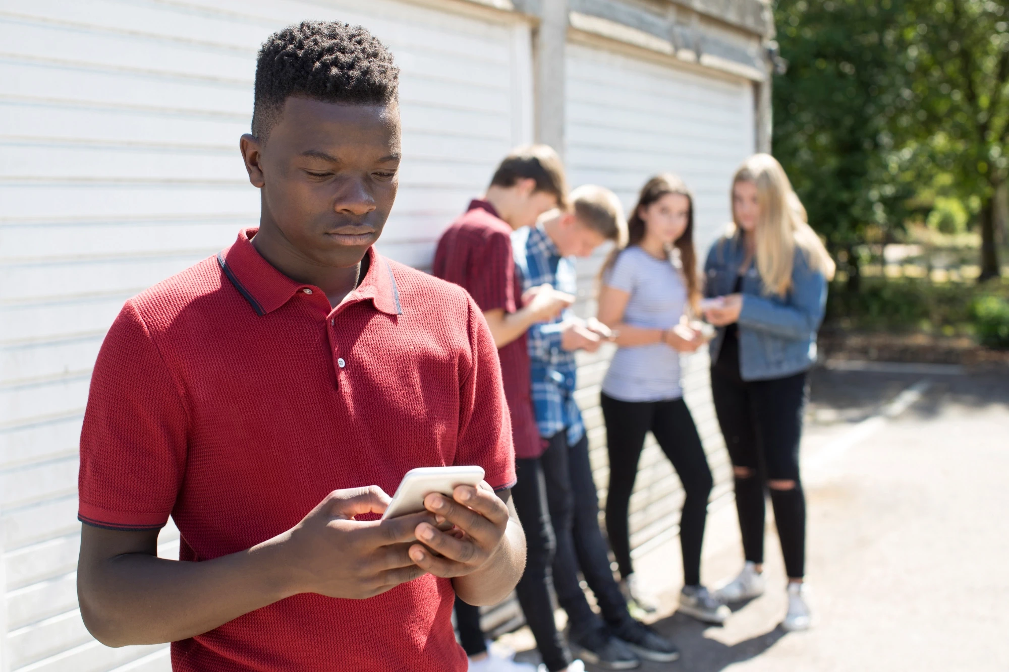 a sad young boy holding a phone
