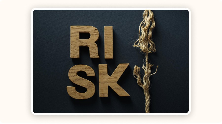 Mot “RISK” en lettres en bois sur fond sombre avec une corde effilochée