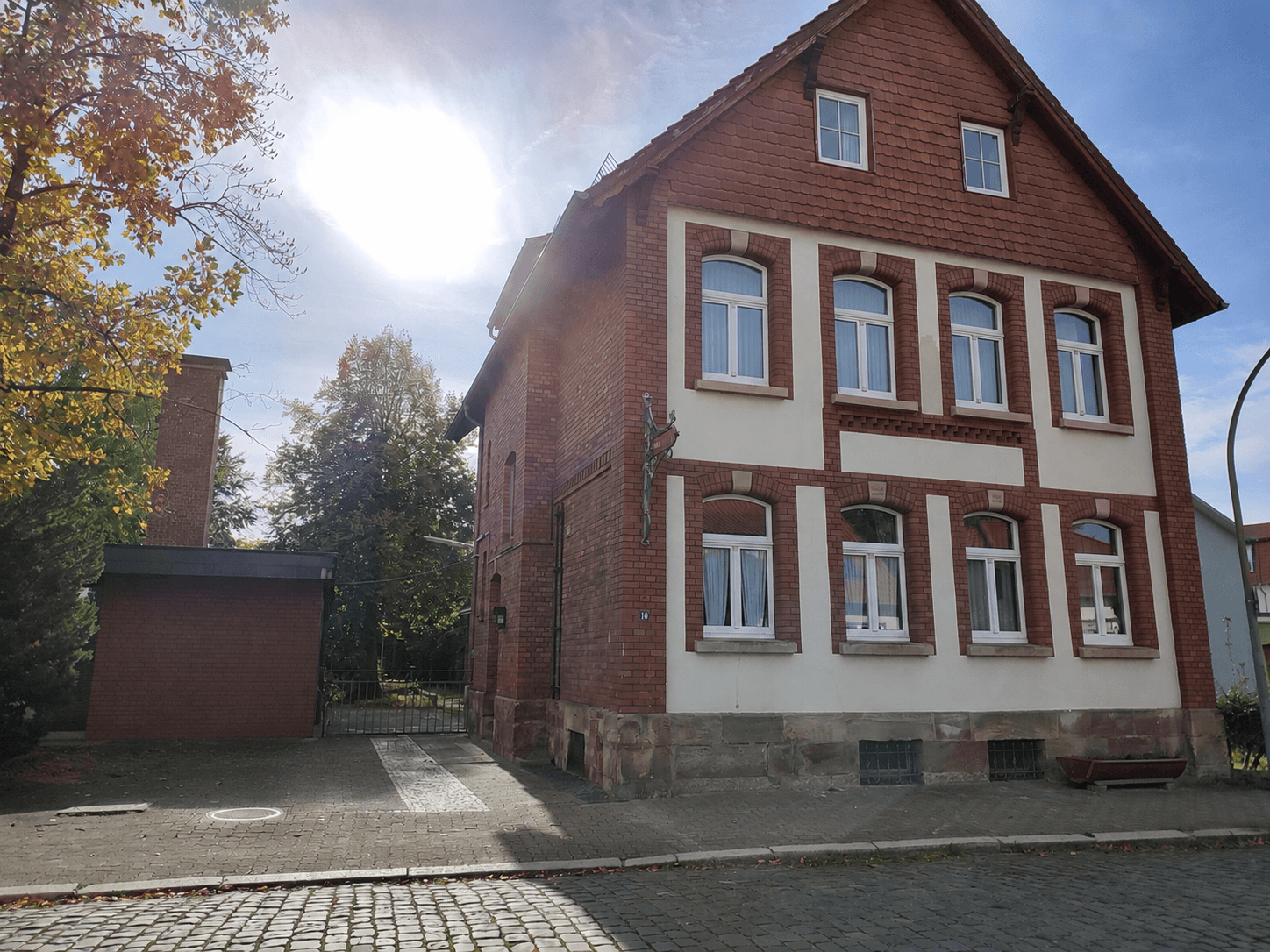 Altes schönes Ziegelsteinhaus mit weißer Fensterwand