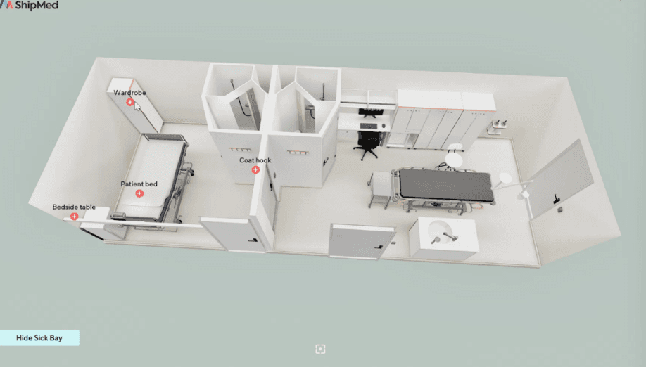 A presenter stands in front of a group, discussing a topic, with a digital screen displaying content behind them.