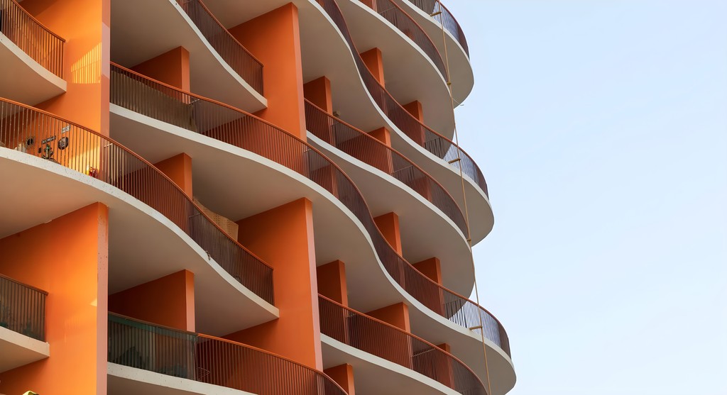 Binghatti Horizons, a tall building with a distinctive curved facade, is positioned along the roadside.