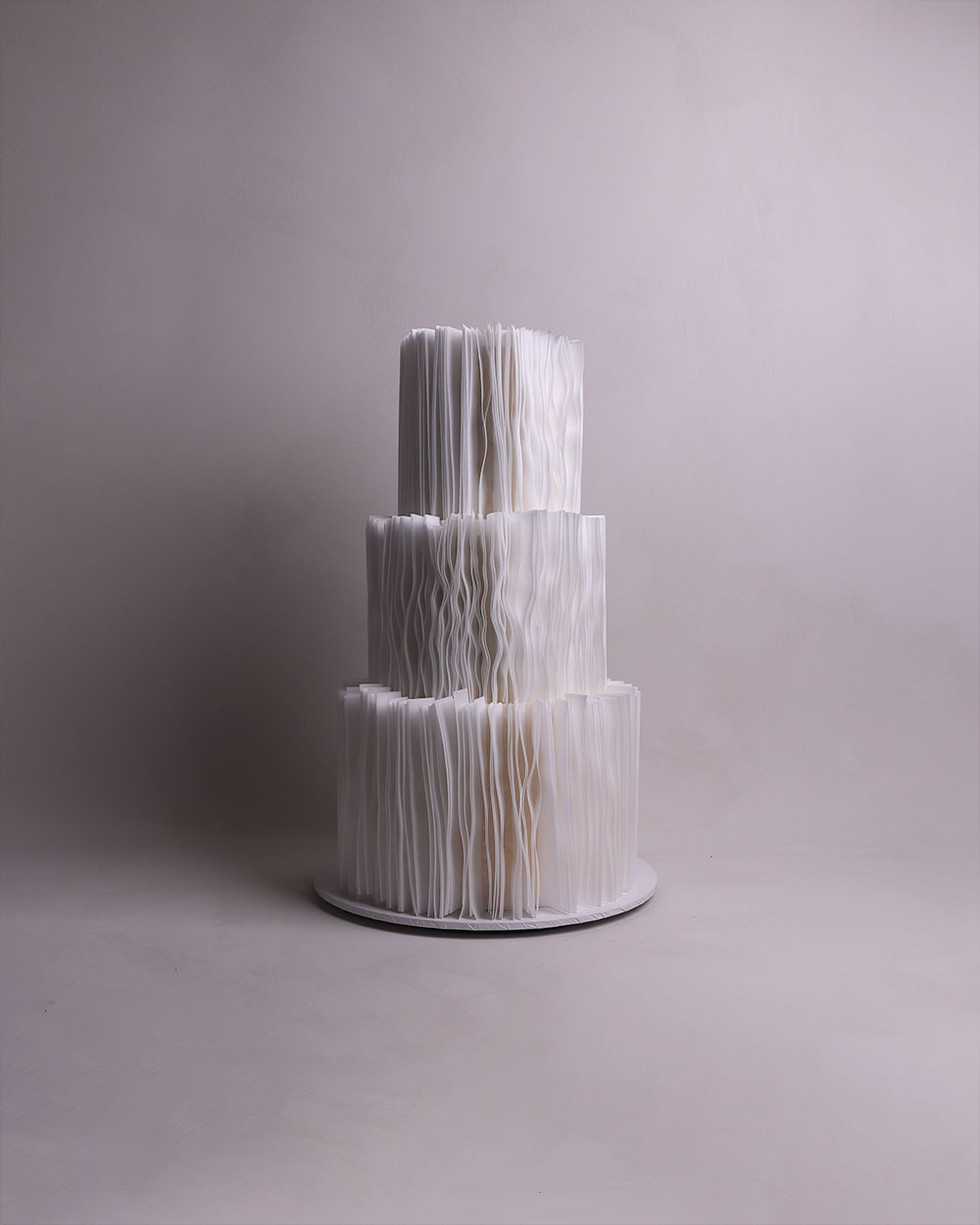 3 tier white wedding cake with fondant draping