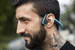 A runner outdoors wearing open-ear headphones