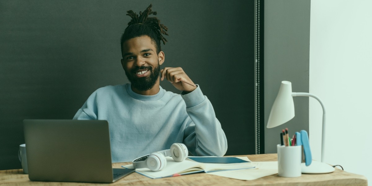 Young jobseeker smiling at his home office desk