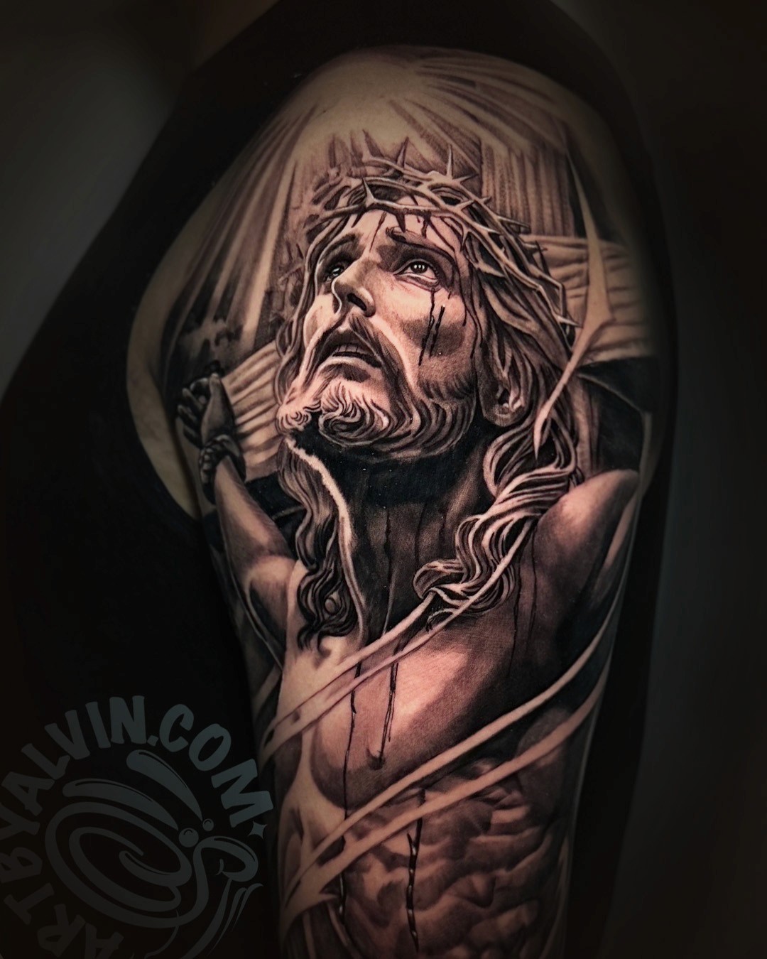 black and gray realism tattoo of jesus on the cross by alvin
