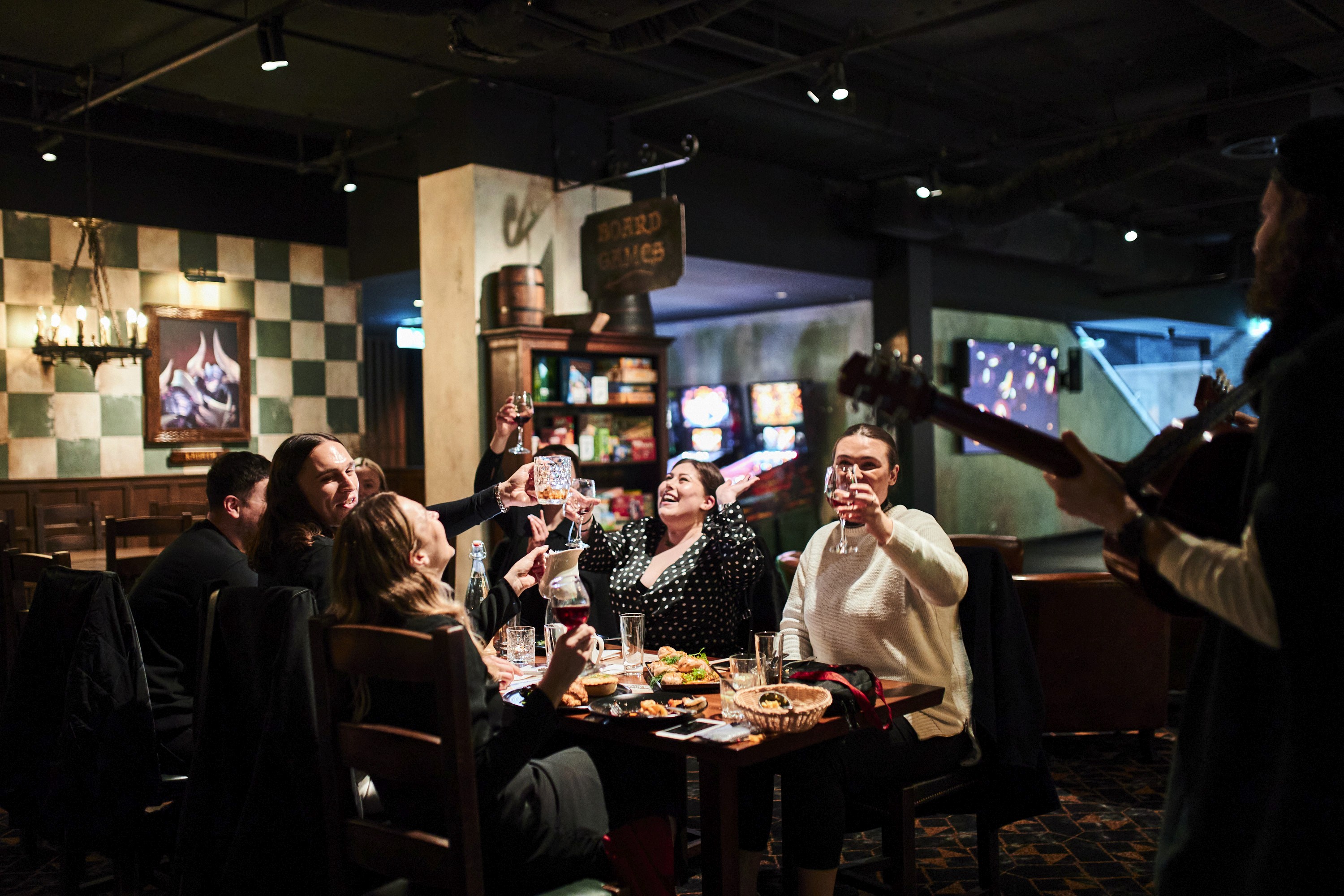 Friends raising a toast at a table in the Fortress tavern