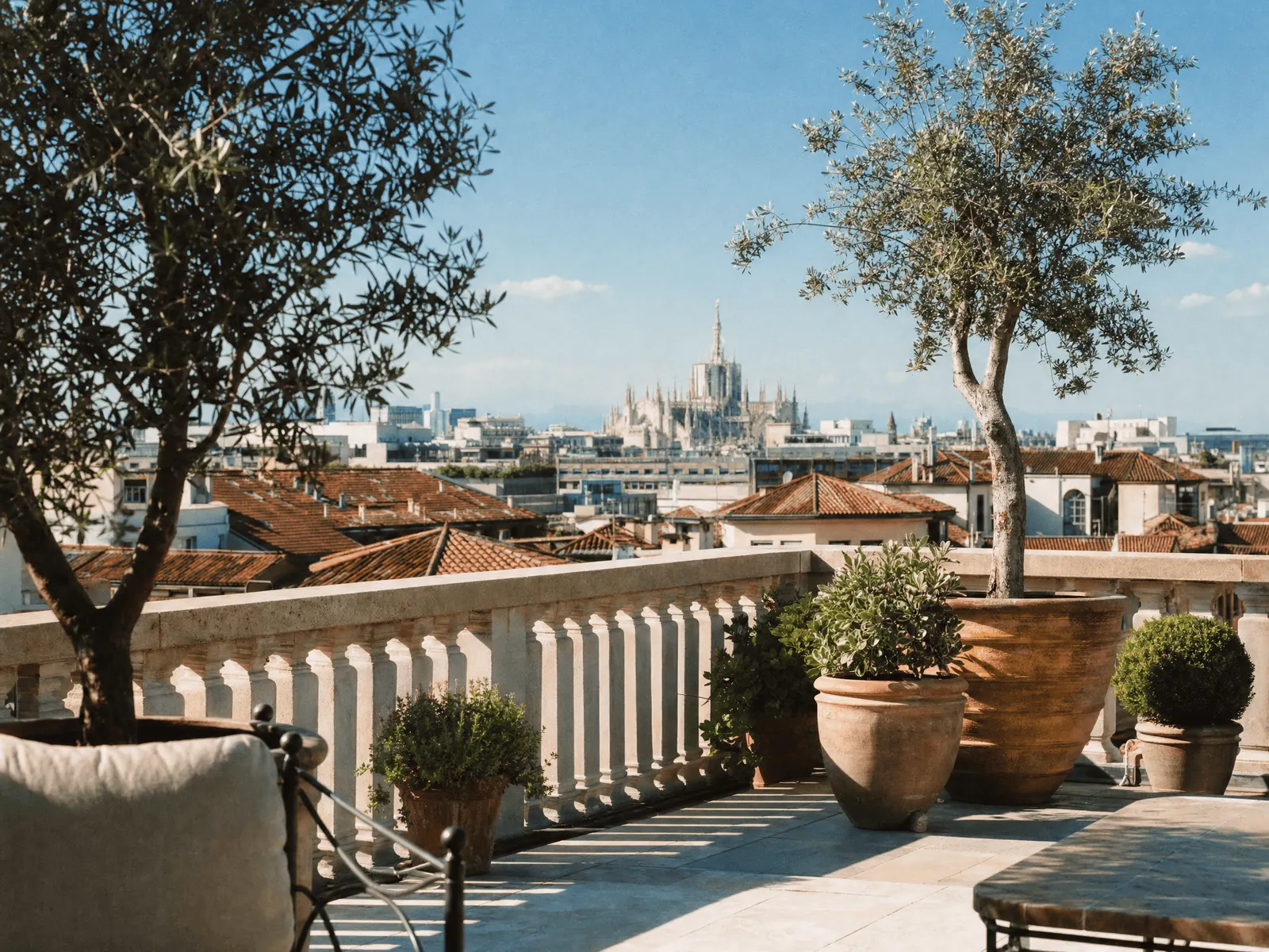 Rooftop terrace with olive trees overlooking Milan's skyline and the Duomo