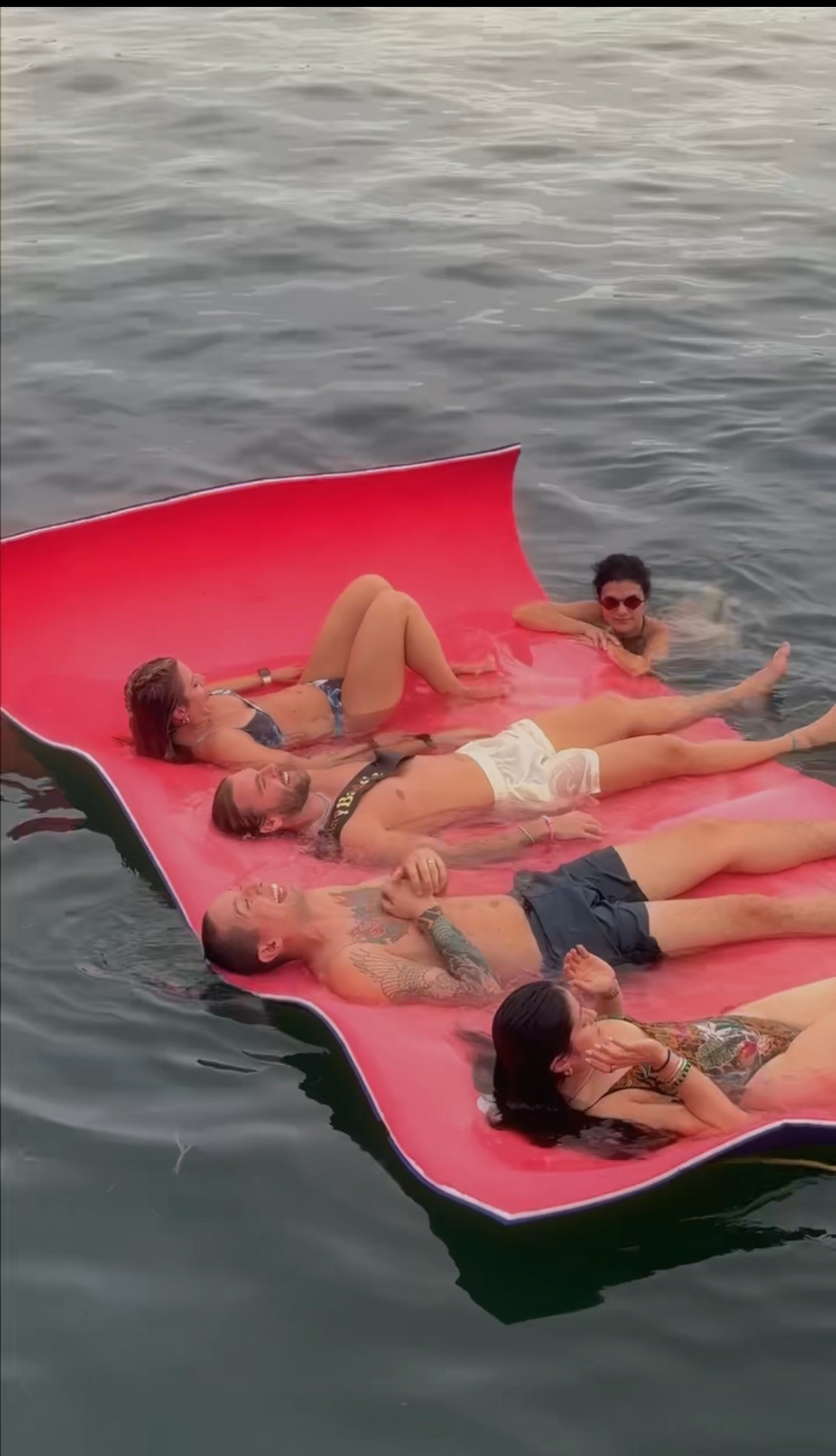 silhouette of man and woman holding fishing rod standing on dock during sunset