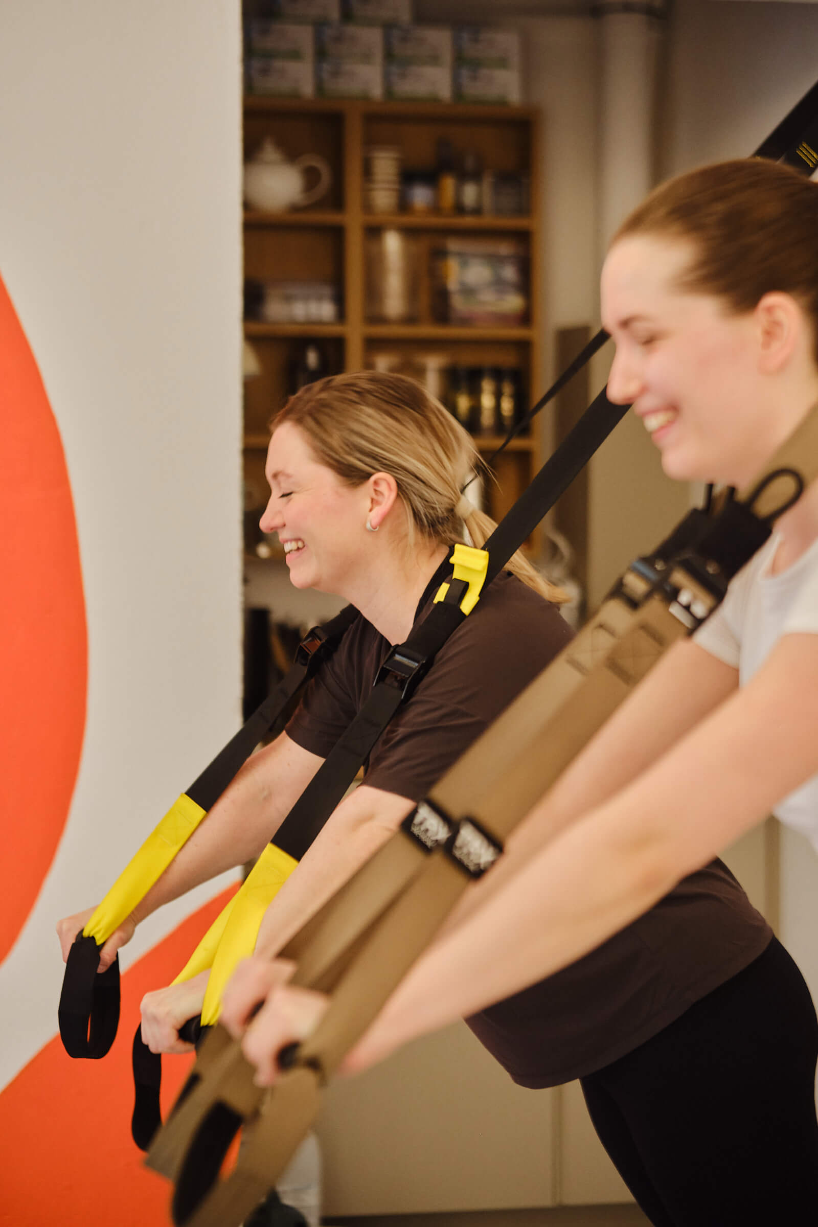 Pilates instructor guides two women