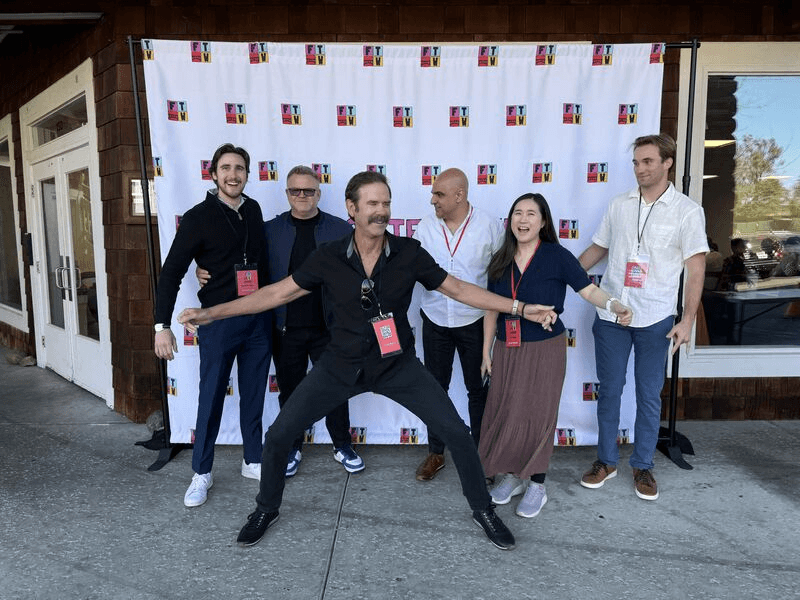 man standing in front of people sitting beside table with laptop computers