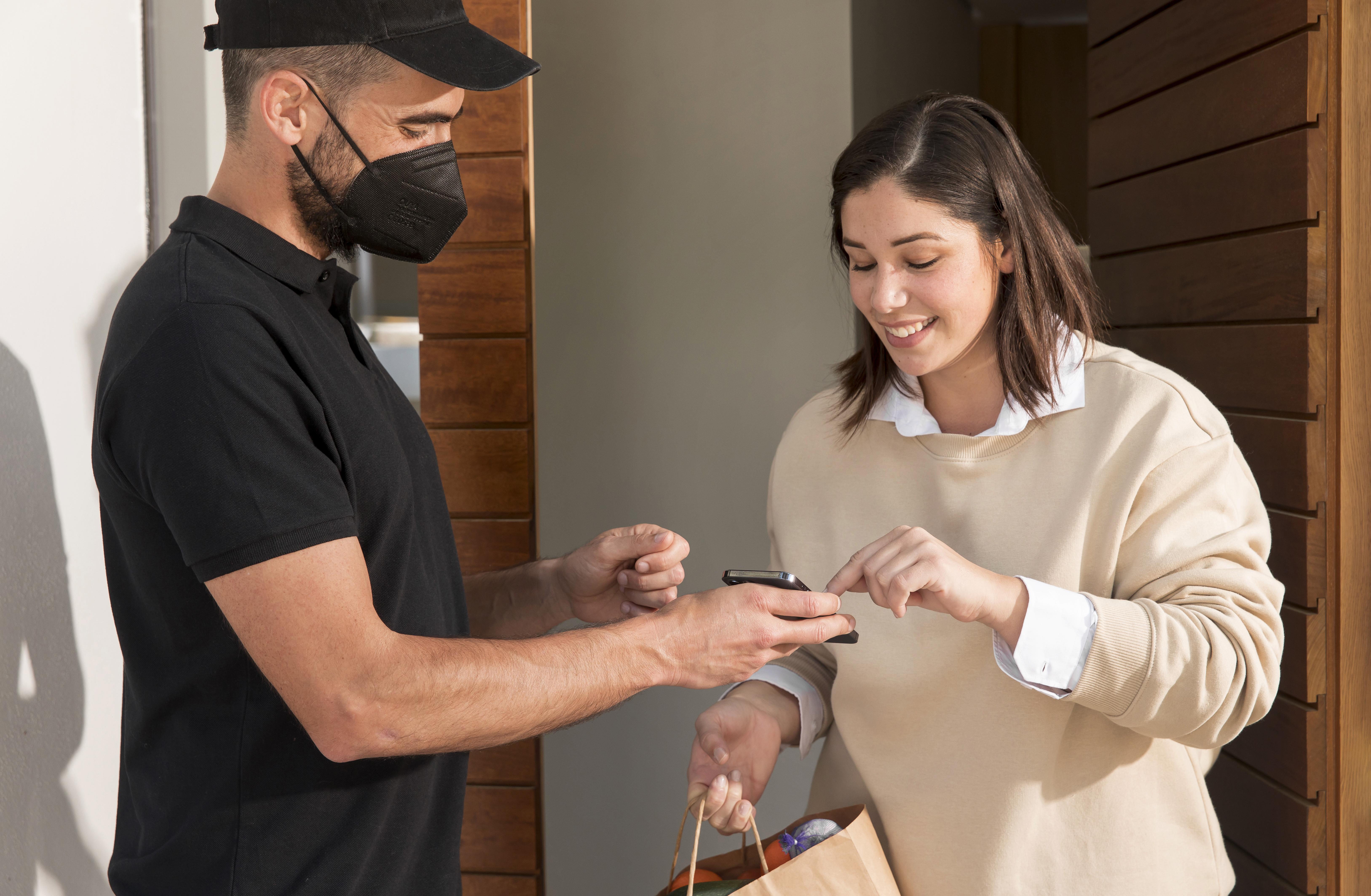 Delivery worker assisting customer with mobile confirmation, illustrating smooth return and refund handling on TikTok Shop.
