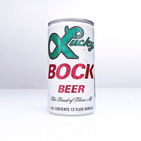 Vintage Lucky Bock beer can with a green script logo and the line the finest of them all, shot against a plain white studio background.