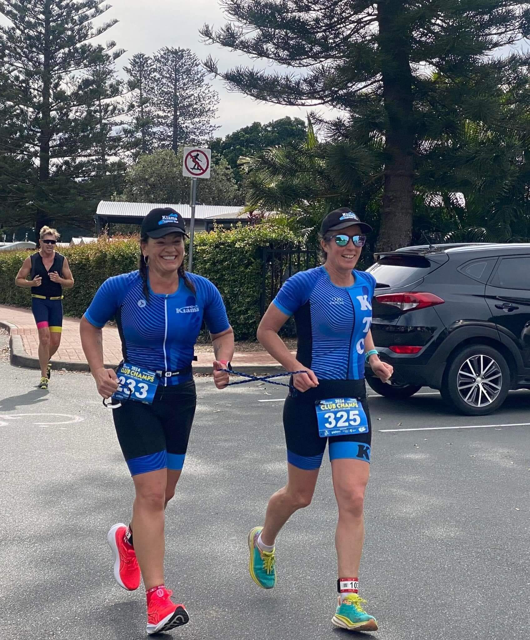 Lily and her guide, Jodie, smiling broadly in celebration coming over the finish line at the NSW trithalon club championships