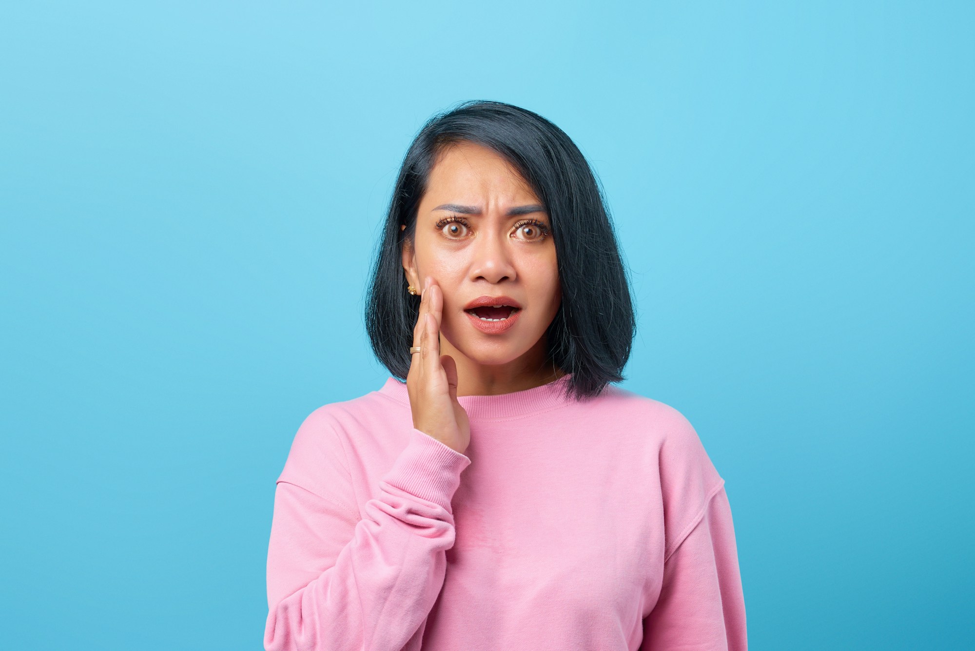Woman holding her cheek with tooth pain