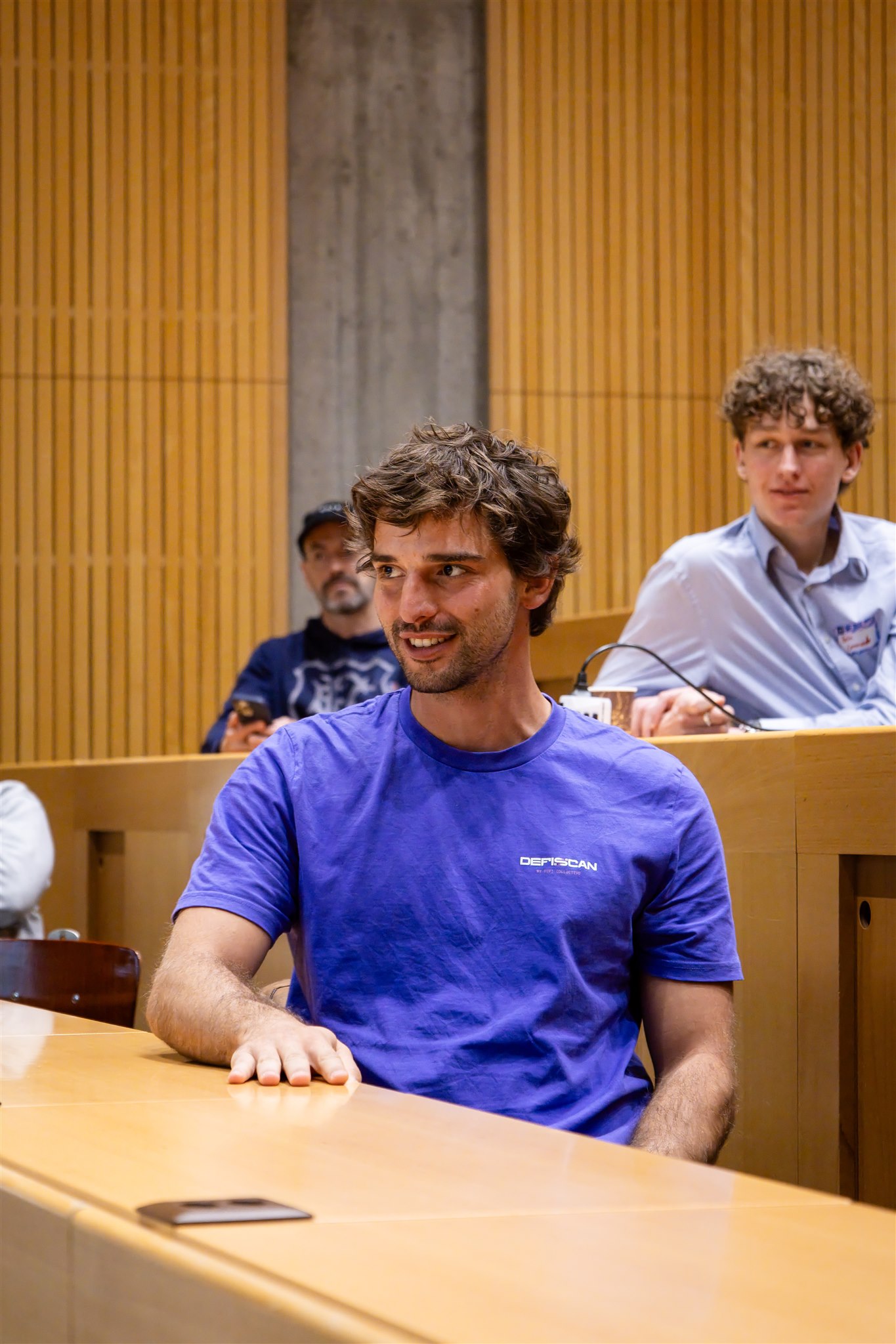 Attendee smiling during EthereumZüri session in Zurich lecture hall